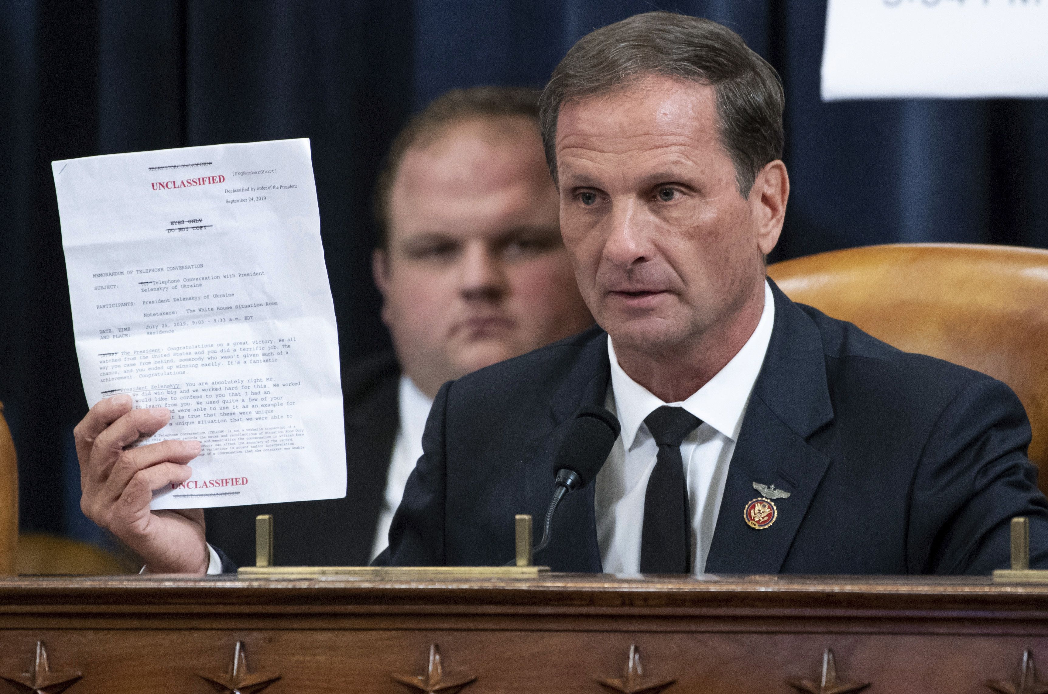 Rep. Chris Stewart, R-Utah, holds up a copy of the transcript of a phone call between President Donald Trump and Ukrainian President Volodymyr Zelenskiy during the House Intelligence Committee on Capitol Hill in Washington, Nov. 13, 2019, in the first public impeachment hearing of President Donald Trump’s efforts to tie U.S. aid for Ukraine to investigations of his political opponents.