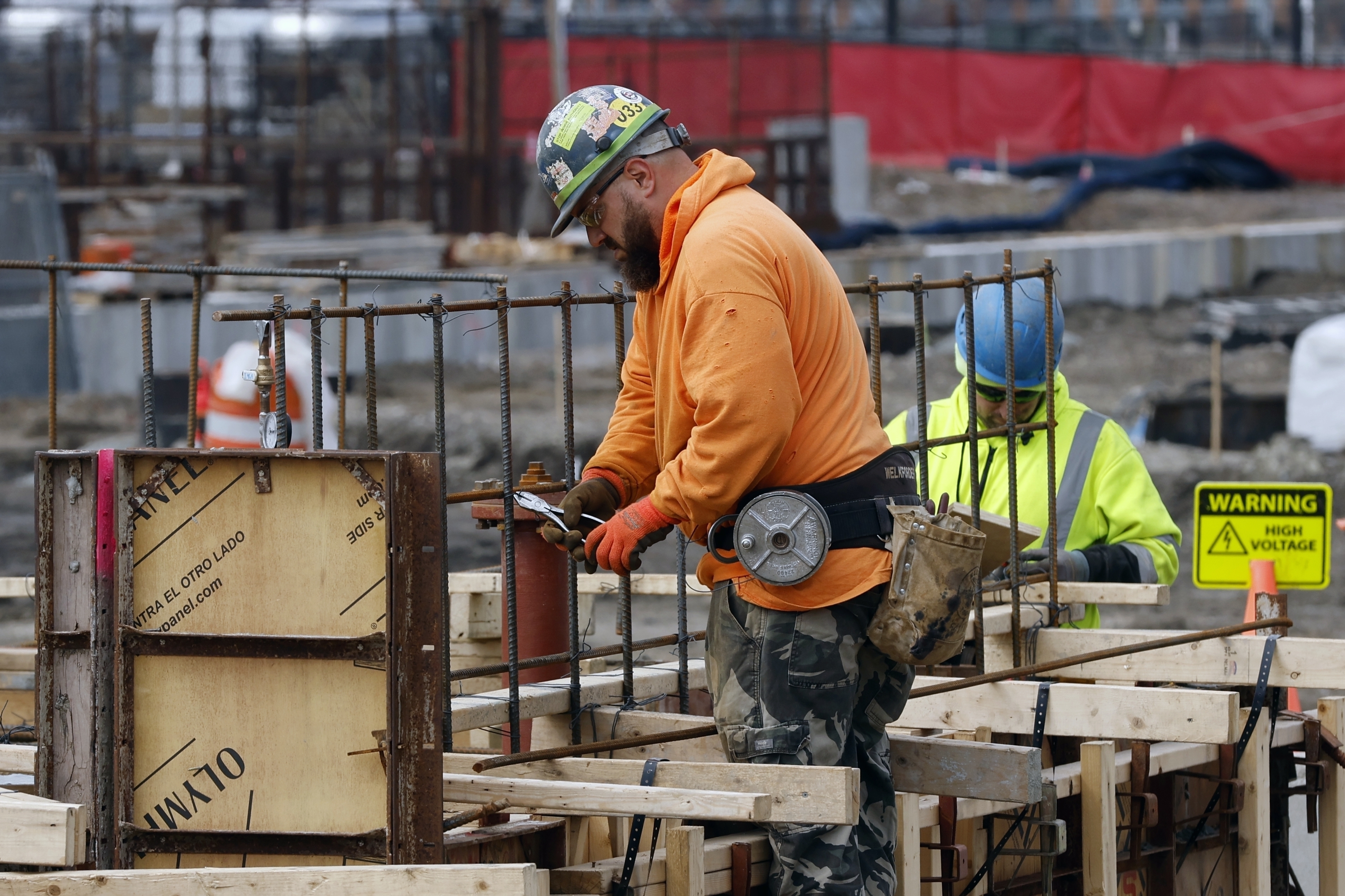A construction worker wires rebar for a foundation, March 17, in Boston. The nation's employers added a solid 187,000 jobs in August, the U.S. government reported Friday.