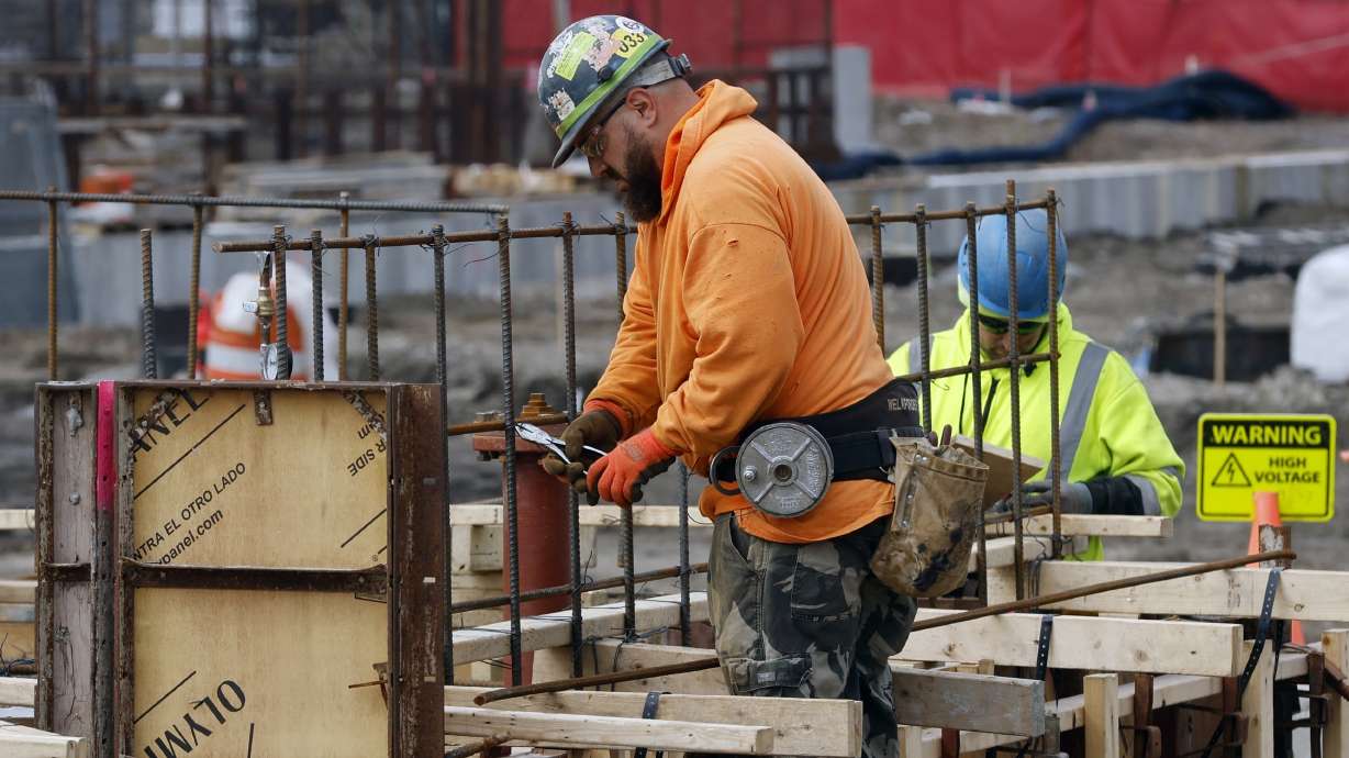 A construction worker wires rebar for a foundation, March 17, in Boston. The nation's employers added a solid 187,000 jobs in August, the U.S. government reported Friday.