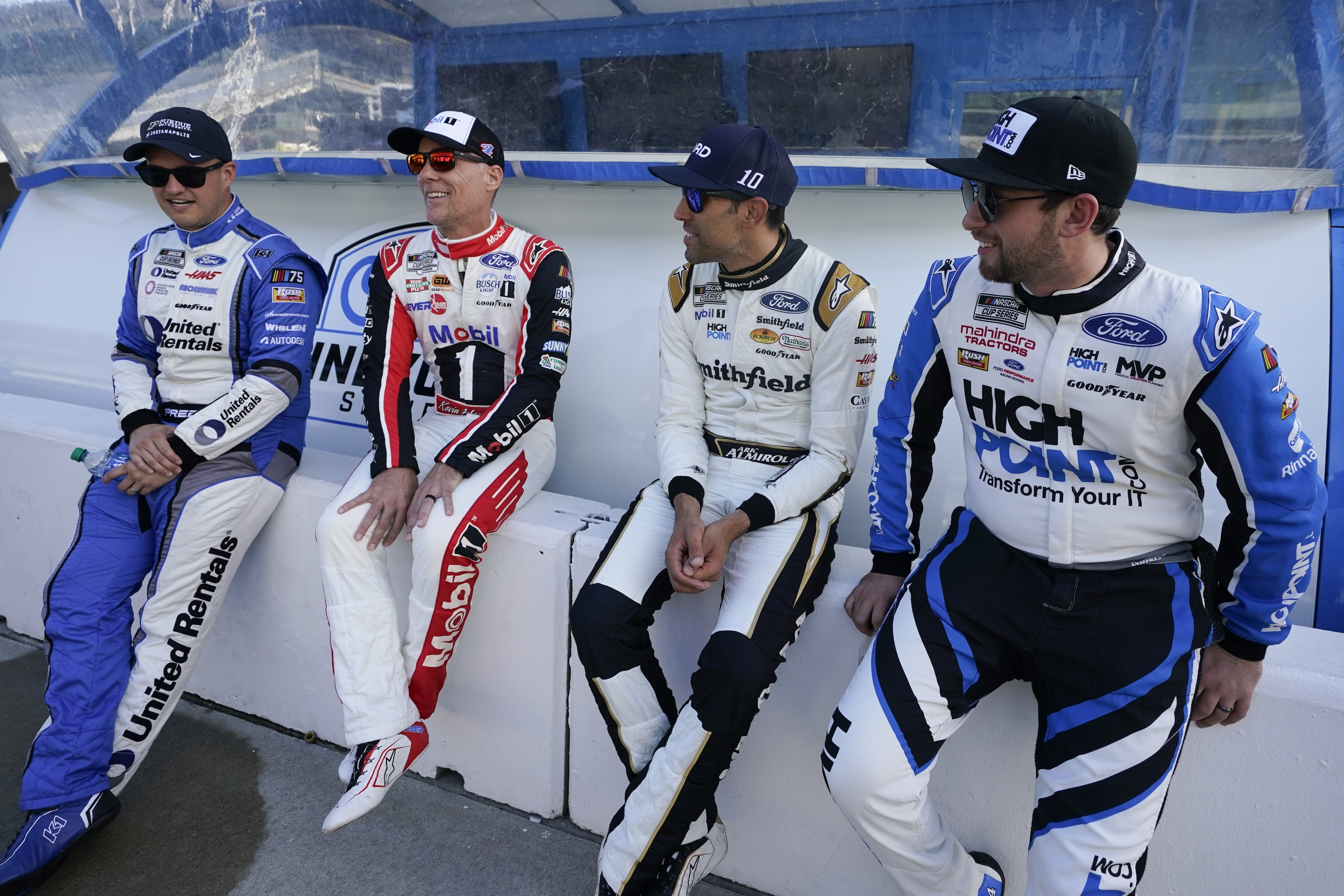 Ryan Preece, Kevin Harvick, Aric Almirola and Chase Briscoe, from left, talk before a practice session for the NASCAR Cup Series auto race at Indianapolis Motor Speedway, Saturday, Aug. 12, 2023, in Indianapolis.