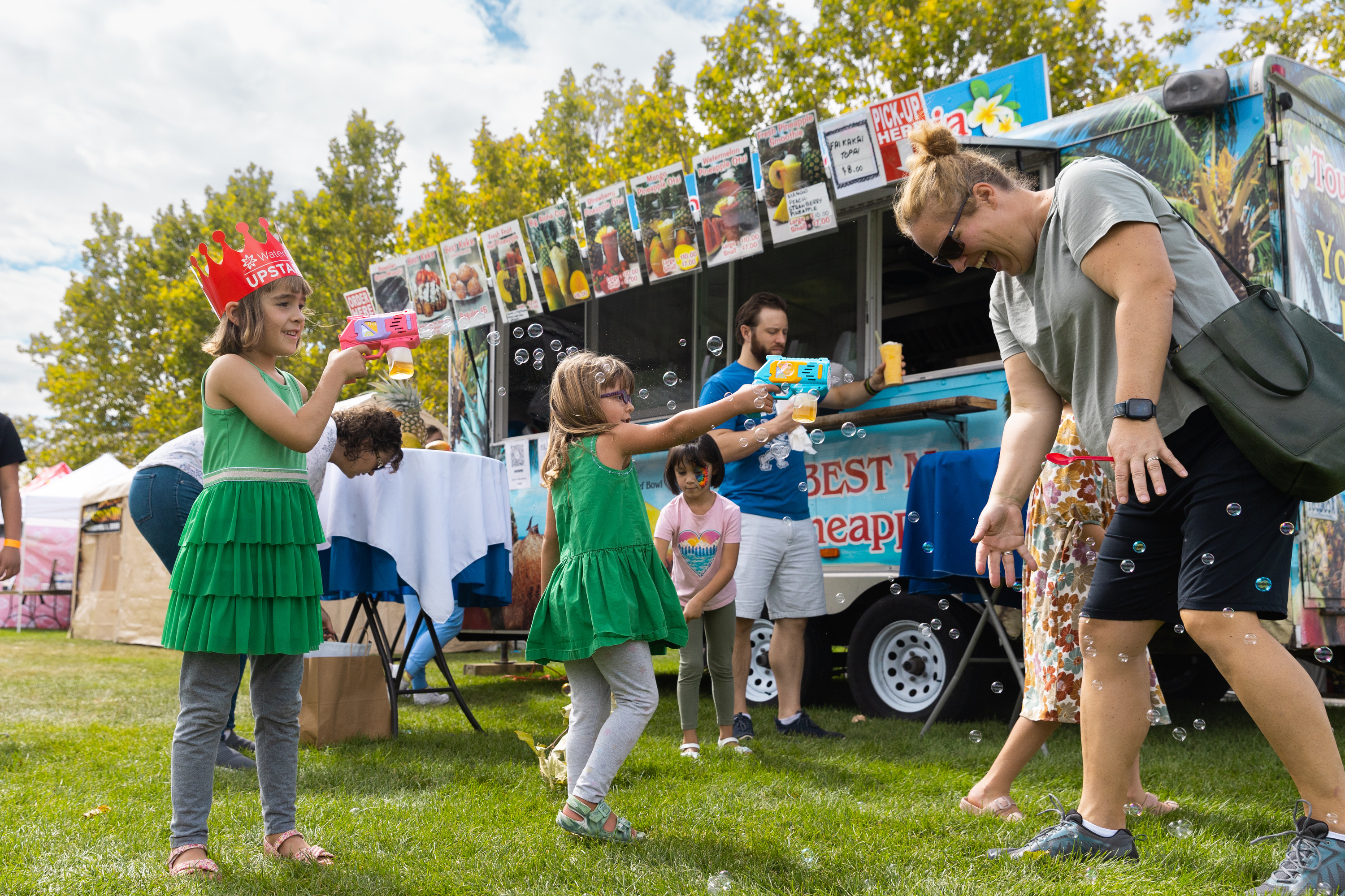 Left to right, Margot and Greta Smith, 6-year-old twins, blow bubbles during Polynesian Days Utah at Electric Park at Thanksgiving Point in Lehi on Saturday.