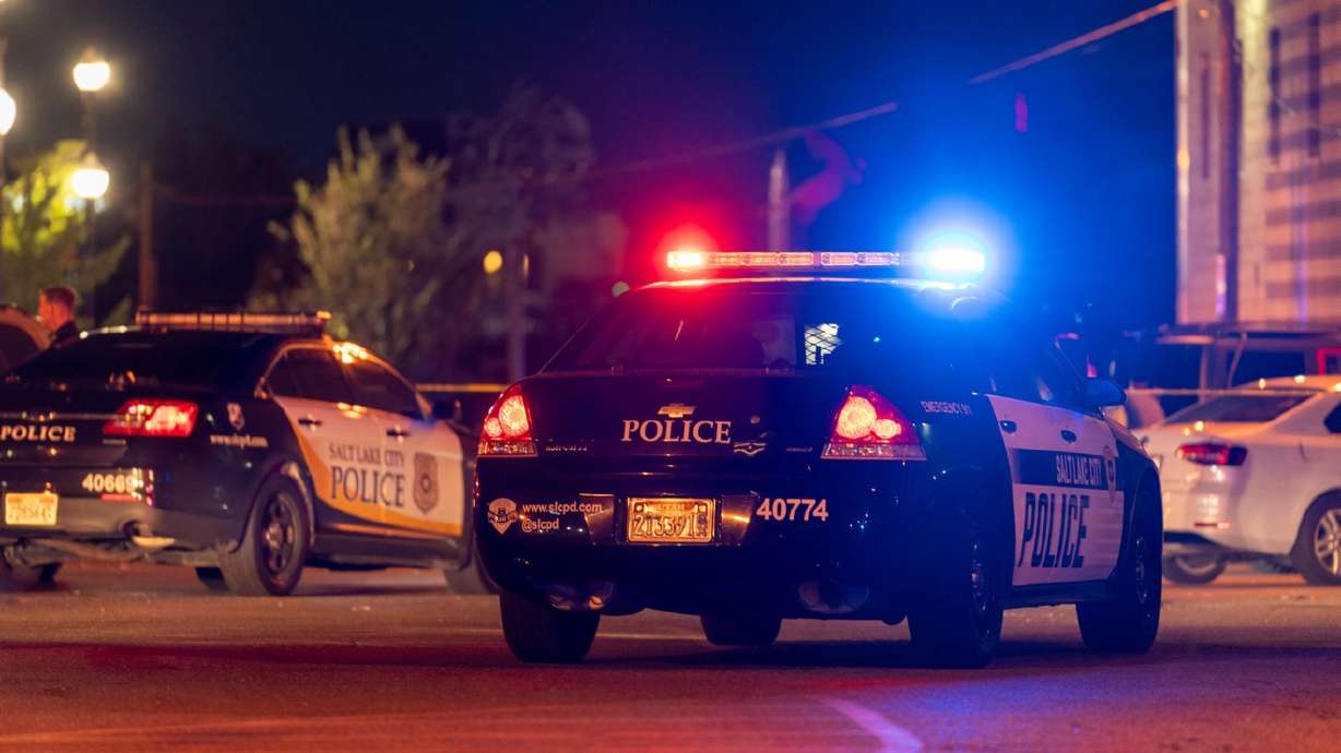 Salt Lake City Police cars respond to a parking lot near 128 W. 300 South following a deadly shooting on Sunday. A man accused of shooting and killing another man in that parking lot has been arrested for investigation of murder.
