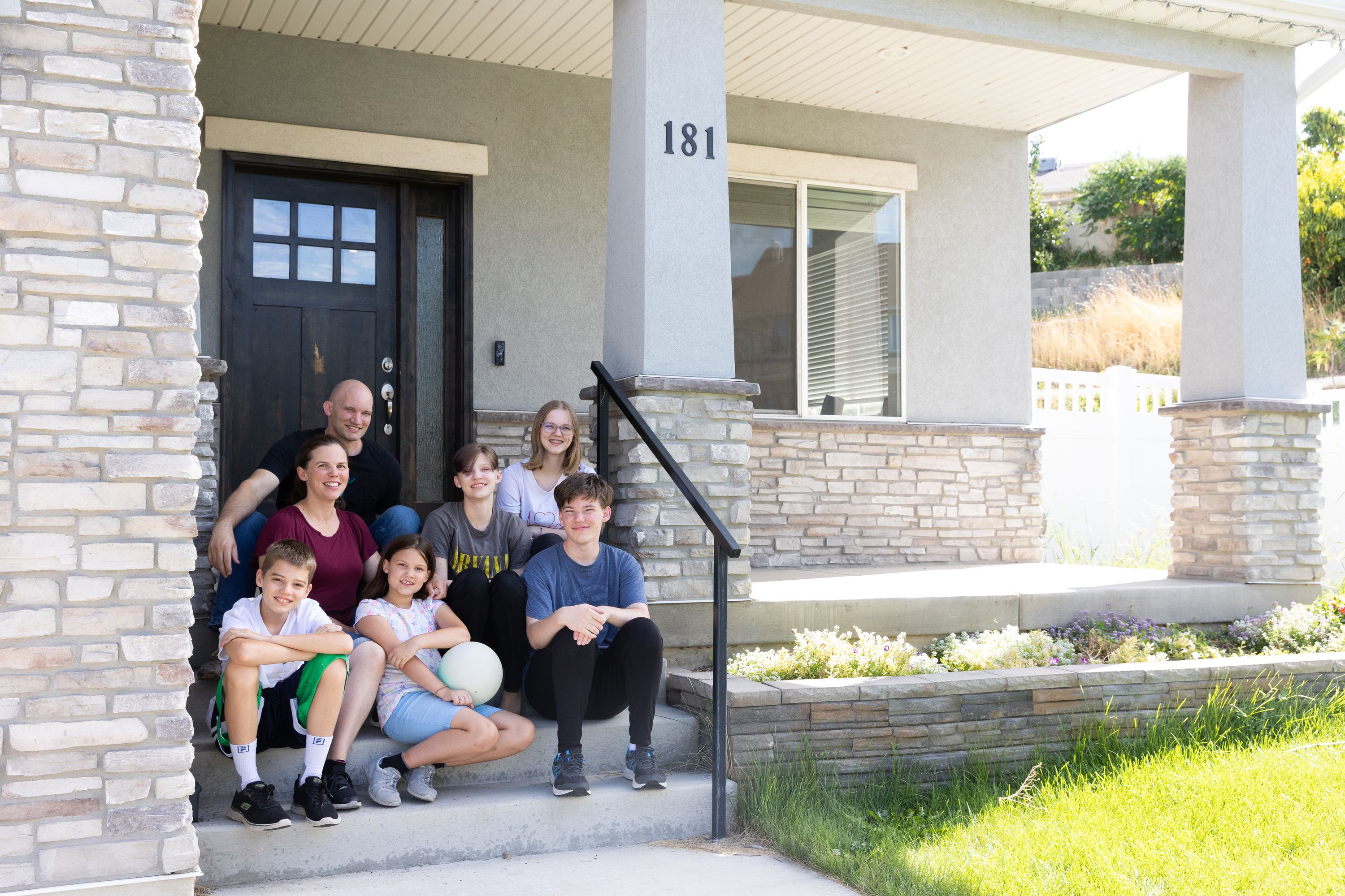 The Cox family smiles for a portrait on the front porch of their home in Lindon on Aug. 26.