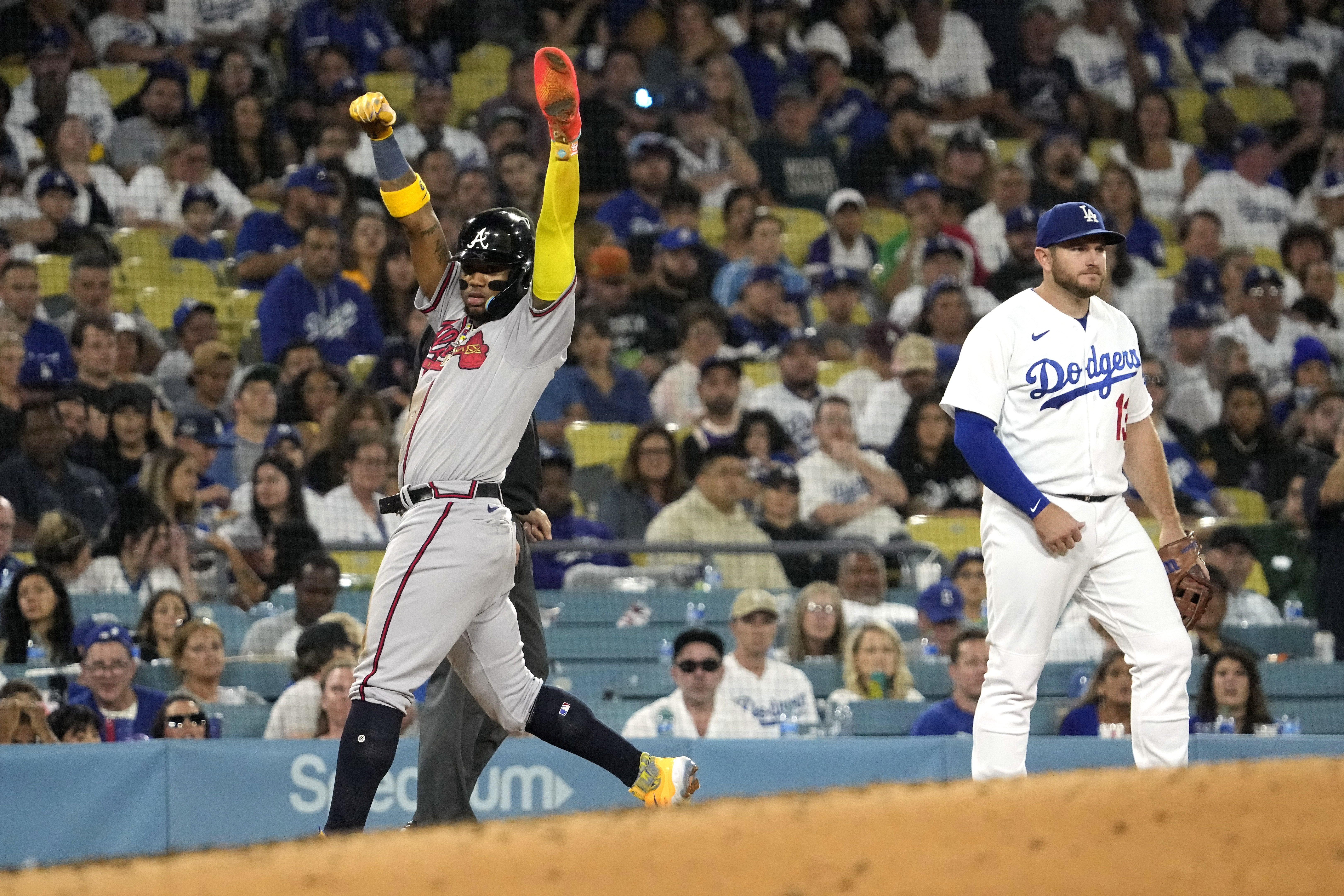 Atlanta Braves' Ronald Acuna Jr., left, celebrates after stealing third as Los Angeles Dodgers third baseman Max Muncy stands by during the fifth inning of a baseball game Friday, Sept. 1, 2023, in Los Angeles.