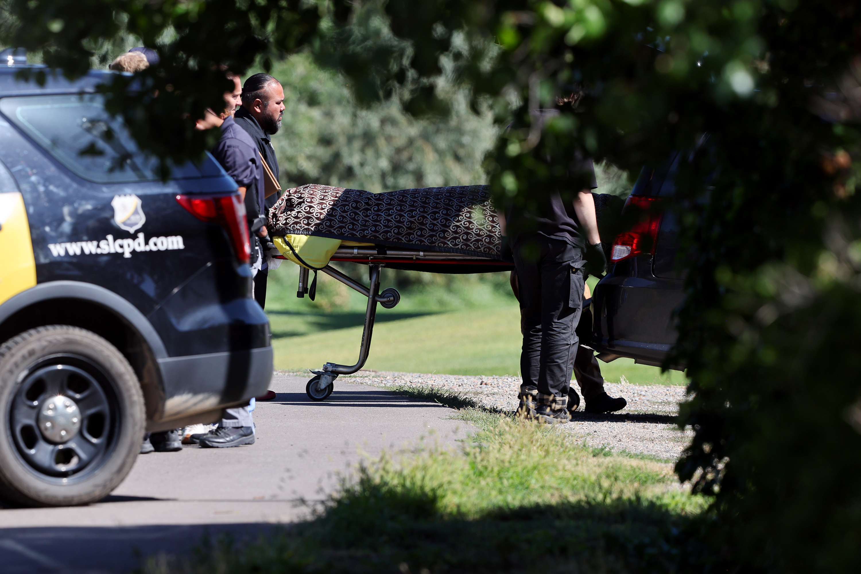 A body is carried to a medical examiner's vehicle at Rose Park Golf Course in Salt Lake City after it was found in the Jordan River on Tuesday.