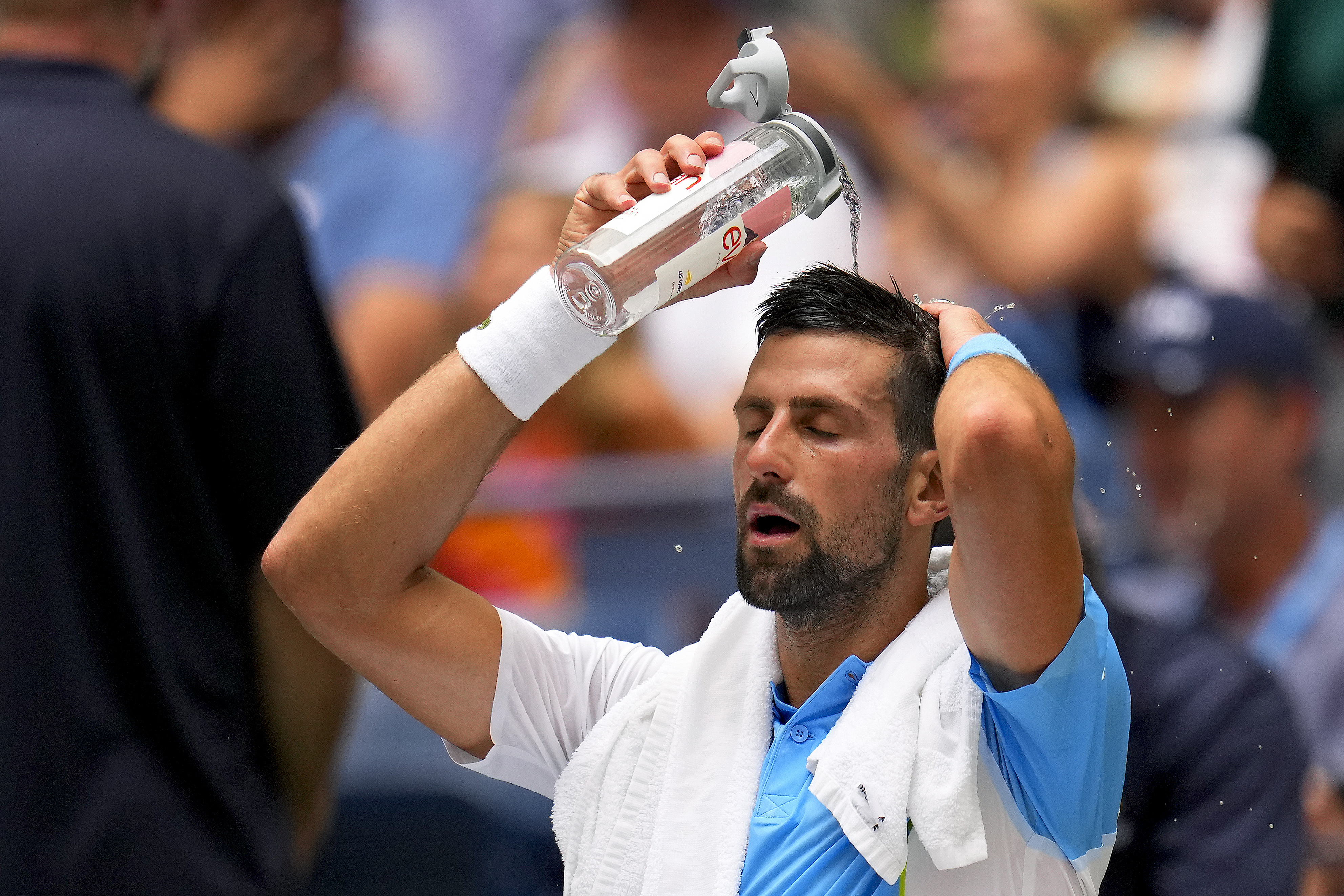 Novak Djokovic, of Serbia, pours water on his head to cool off between sets against Taylor Fritz, of the United States, during the quarterfinals of the U.S. Open tennis championships, Tuesday, Sept. 5, 2023, in New York. 