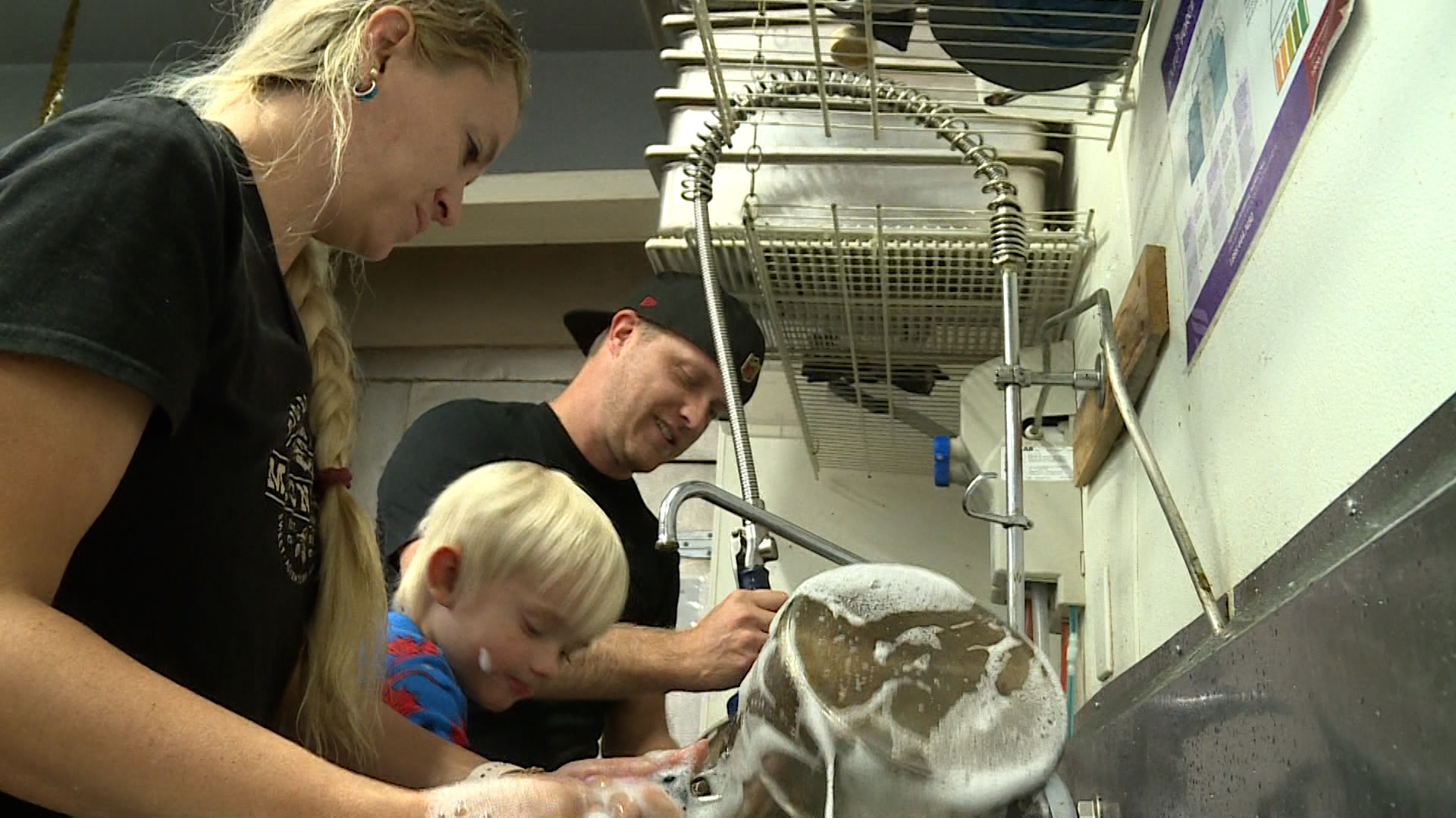 Robert and Kristal Thompson washing the dishes at their resort kitchen.