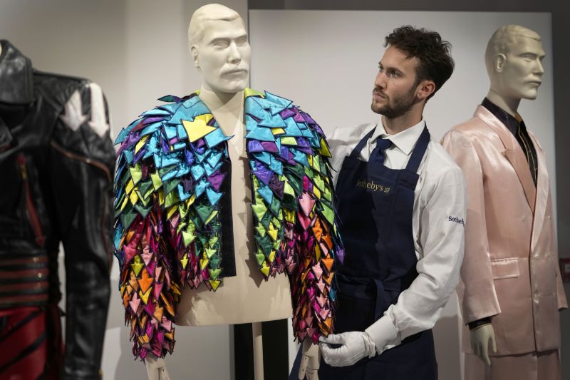A Sotheby's handler displays a Rainbow Coloured Satin Arrow Applique Jacket from 1982 at Sotheby's auction rooms in London, Aug. 3. More than 1,000 of Freddie Mercury's personal items were on show in an exhibition at Sotheby's London ahead of their sale.