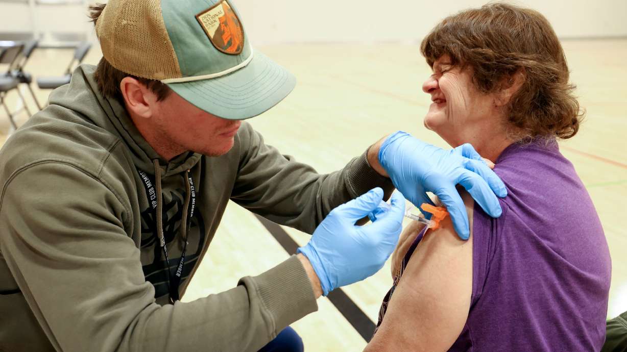 Wyatt Hanvey, a registered nurse with the Salt Lake County Health Department, gives Lisa Roush a COVID-19 booster shot during a free vaccine clinic at the Sanderson Community Center in Taylorsville on Nov. 9, 2022. The FDA intends to give the go-ahead for the updated vaccine as soon as Friday.
