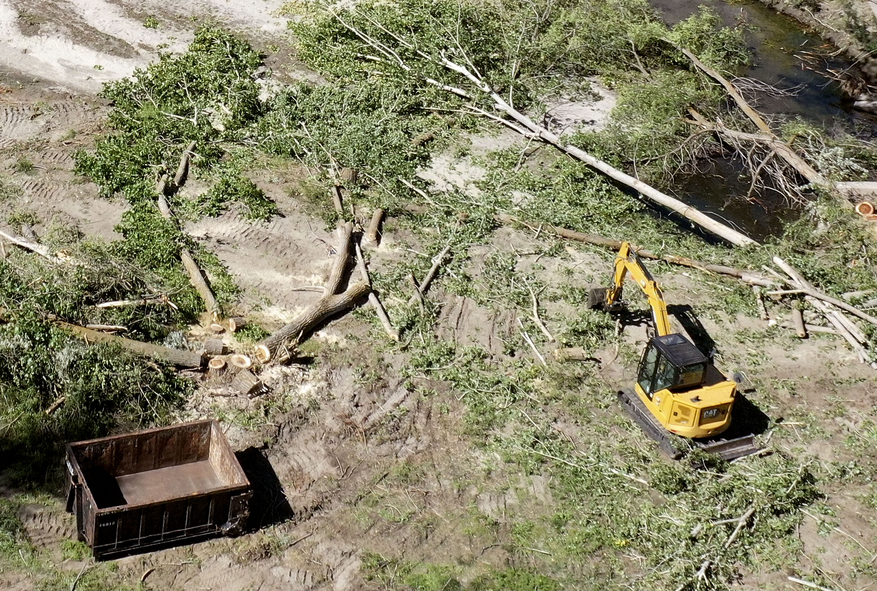 Downed trees and debris are cleared up along Cottonwood Creek at Wheeler Farm in Murray on Thursday.