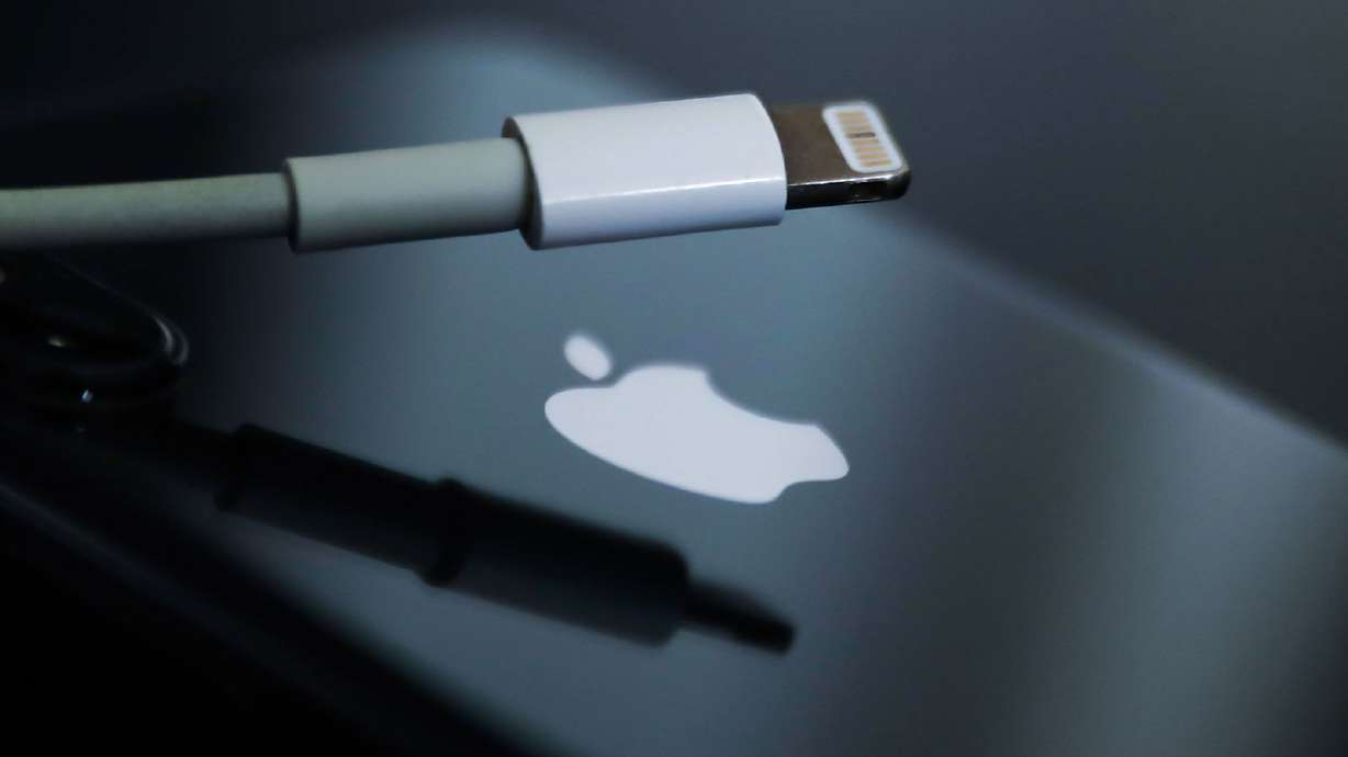 Lightning cable and Apple logo on iPhone are seen in this illustration photo taken in Krakow, Poland on Sept. 25, 2021. Apple is set to unveil the iPhone 15 in just a few days, and it's widely expected to come with a significant change.