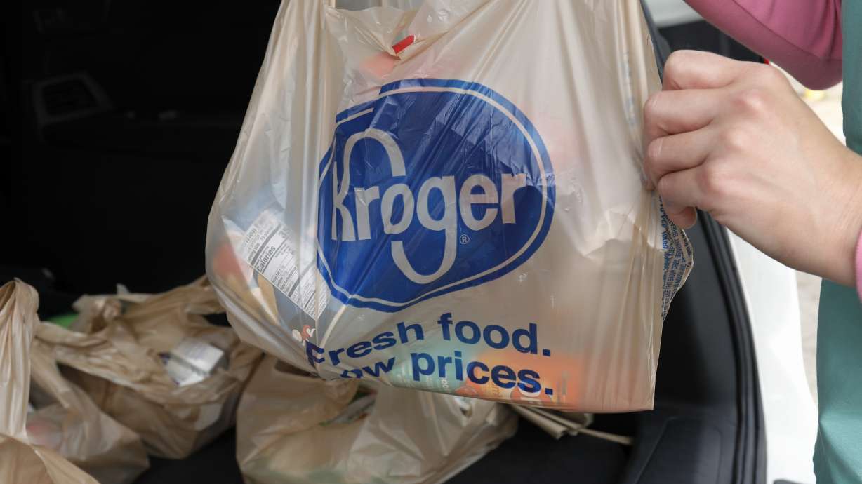 A customer removes her purchases at a Kroger grocery store in Flowood, Miss., June 26, 2019. Kroger and Albertsons are selling more than 400 stores and other assets to C&S Wholesale Grocers in an approximately $1.9 billion deal.
