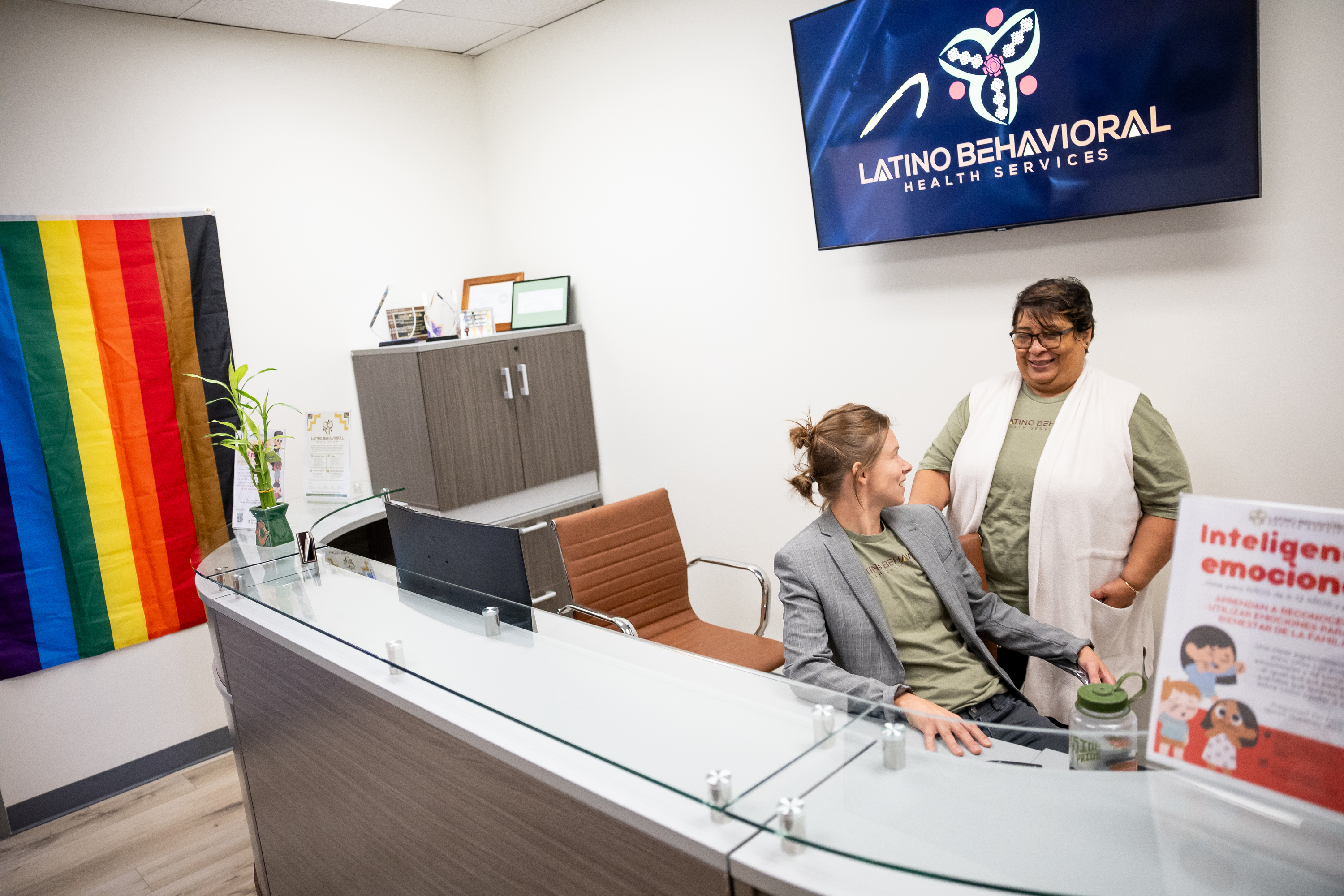 Jules Martinez, clinical director at Latino Behavioral Health Services, chats with Alba Real, who works the front desk, at the organization’s new facility in South Salt Lake on Sept. 7.