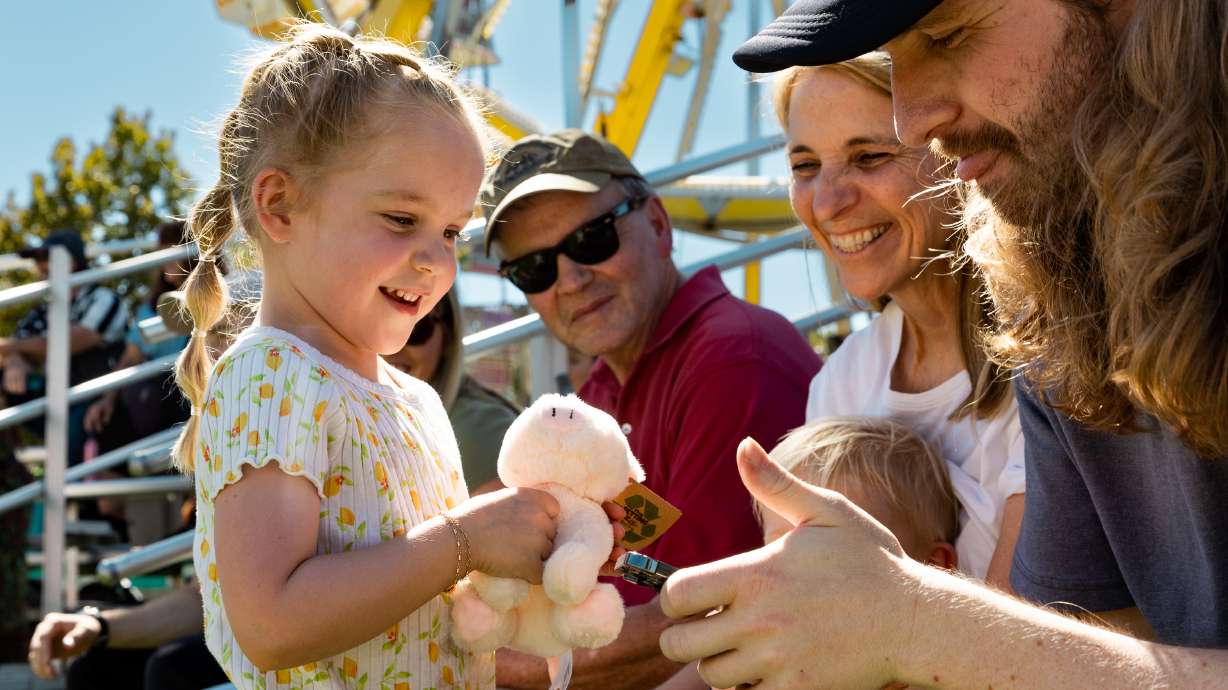 Lyla Mccusker shows off the stuffed pig she won at the Utah State Fair at the Utah State Fairpark in Salt Lake City on Friday.