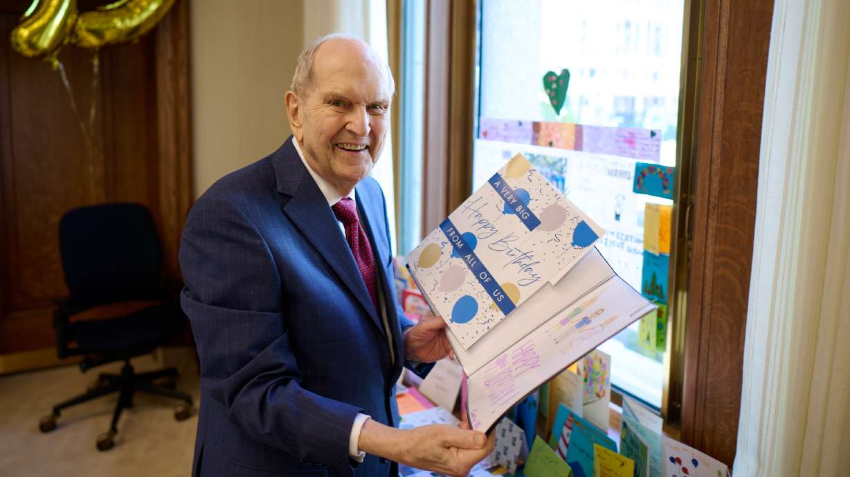 President Russell M. Nelson of The Church of Jesus Christ of Latter-day Saints looks at birthday cards sent to him for his 99th birthday in his office at the Church Administration Building in Salt Lake City on Friday. He turned 99 on Saturday.