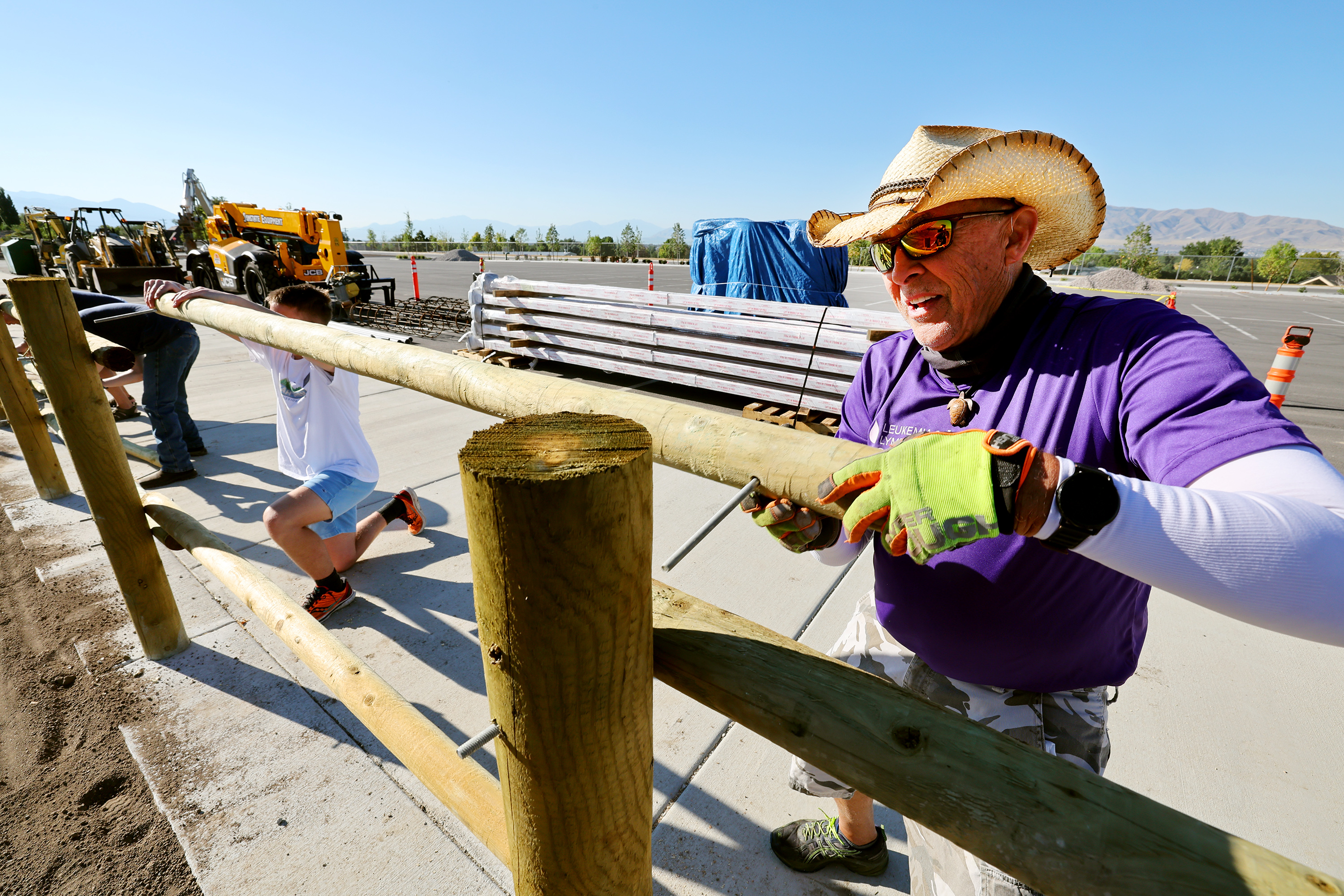 Elder Logan Schulz and Steve Topp install a fence rail as Lehi residents team up to perform service working to install fencing, gravel and other jobs at the new soccer fields and city park on Saturday as part of the 9/11 Day of Service.