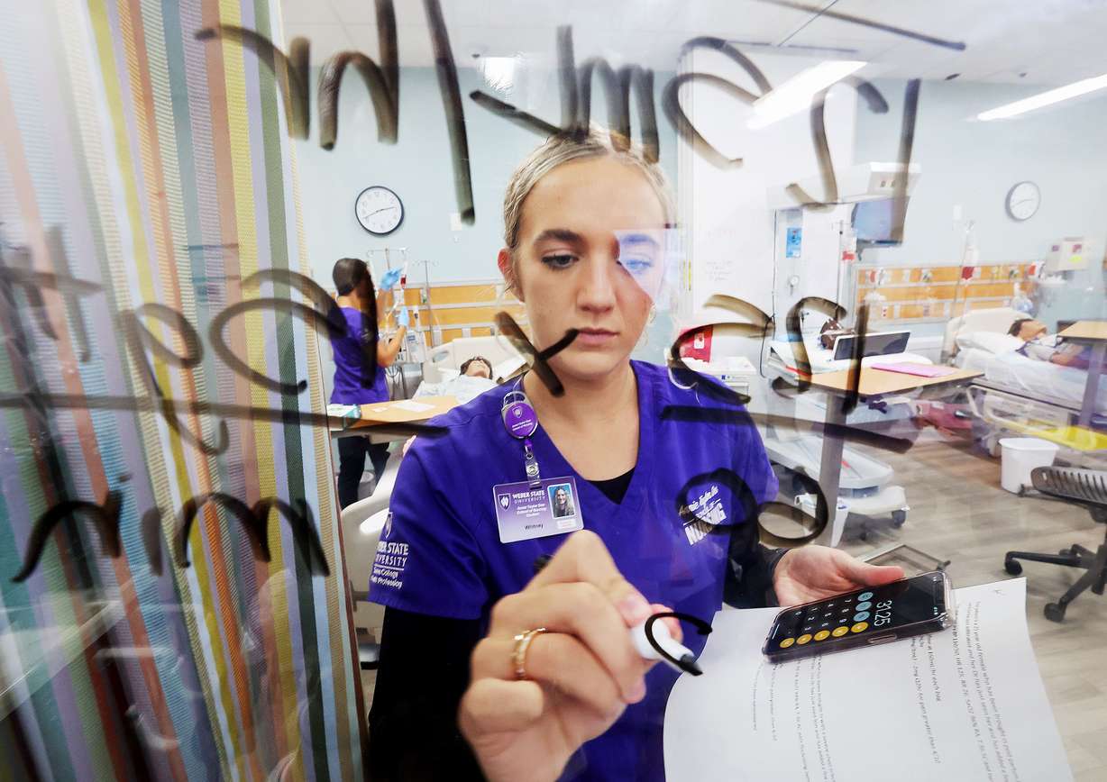 Nursing student Whitney Weston works out a few mathematical problems as she and other students go about their work in the simulation lab in the Marriott Health Building at Weber State University in Ogden on Tuesday.