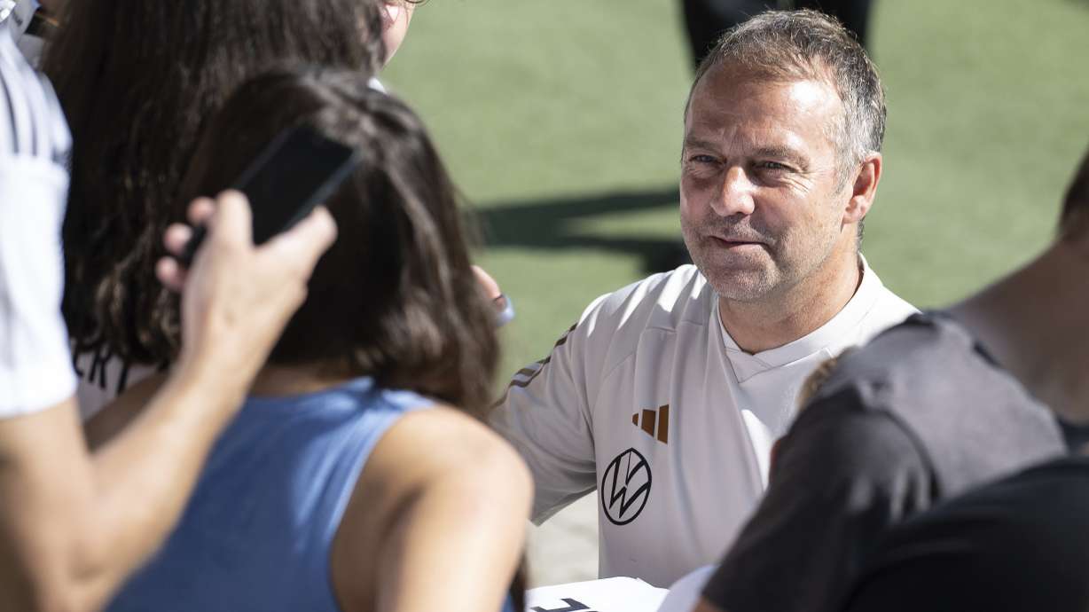 Germany's national soccer coach Hansi Flick signs autographs in Wolfsburg, Germany, Sunday, Sept. 10, 2023. Germany was jeered by its home crowd Saturday after slumping to a 4-1 loss to Japan to pile yet more pressure on coach Hansi Flick, nine months out from hosting the European Championship.
