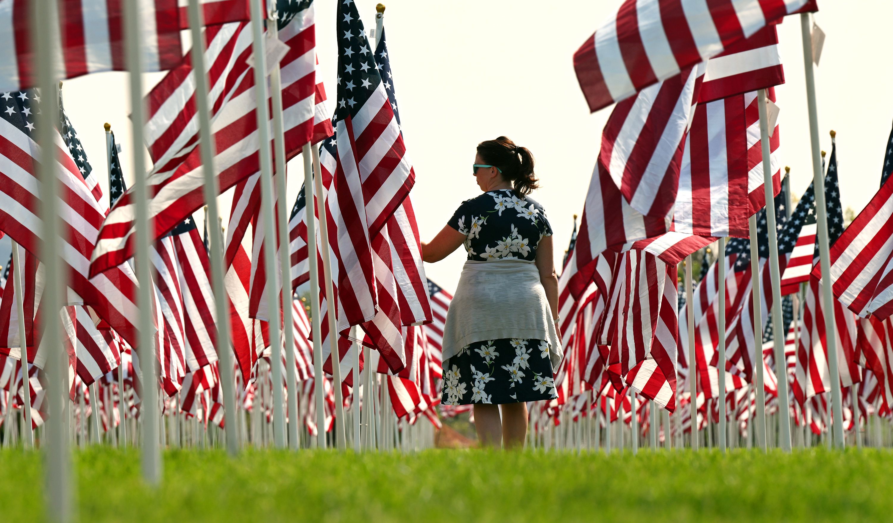 Terrah Anderson reads the cards on the flags as she walks through the Sandy 9/11 Healing Field on Sunday.