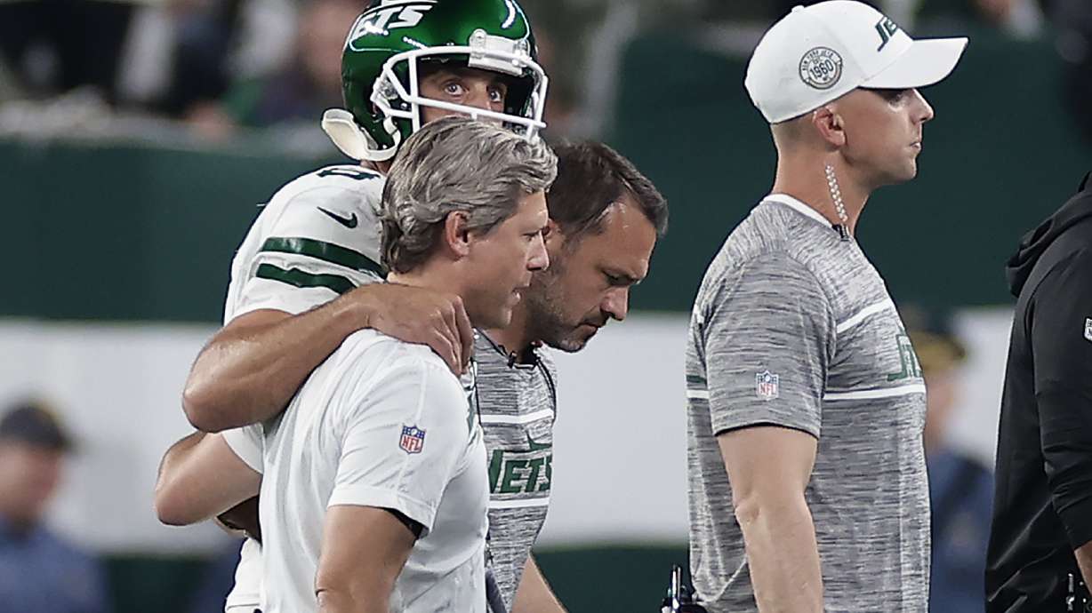 New York Jets quarterback Aaron Rodgers (8) is helped off the field during the first quarter of an NFL football game against the Buffalo Bills, Monday, Sept. 11, 2023, in East Rutherford, N.J.