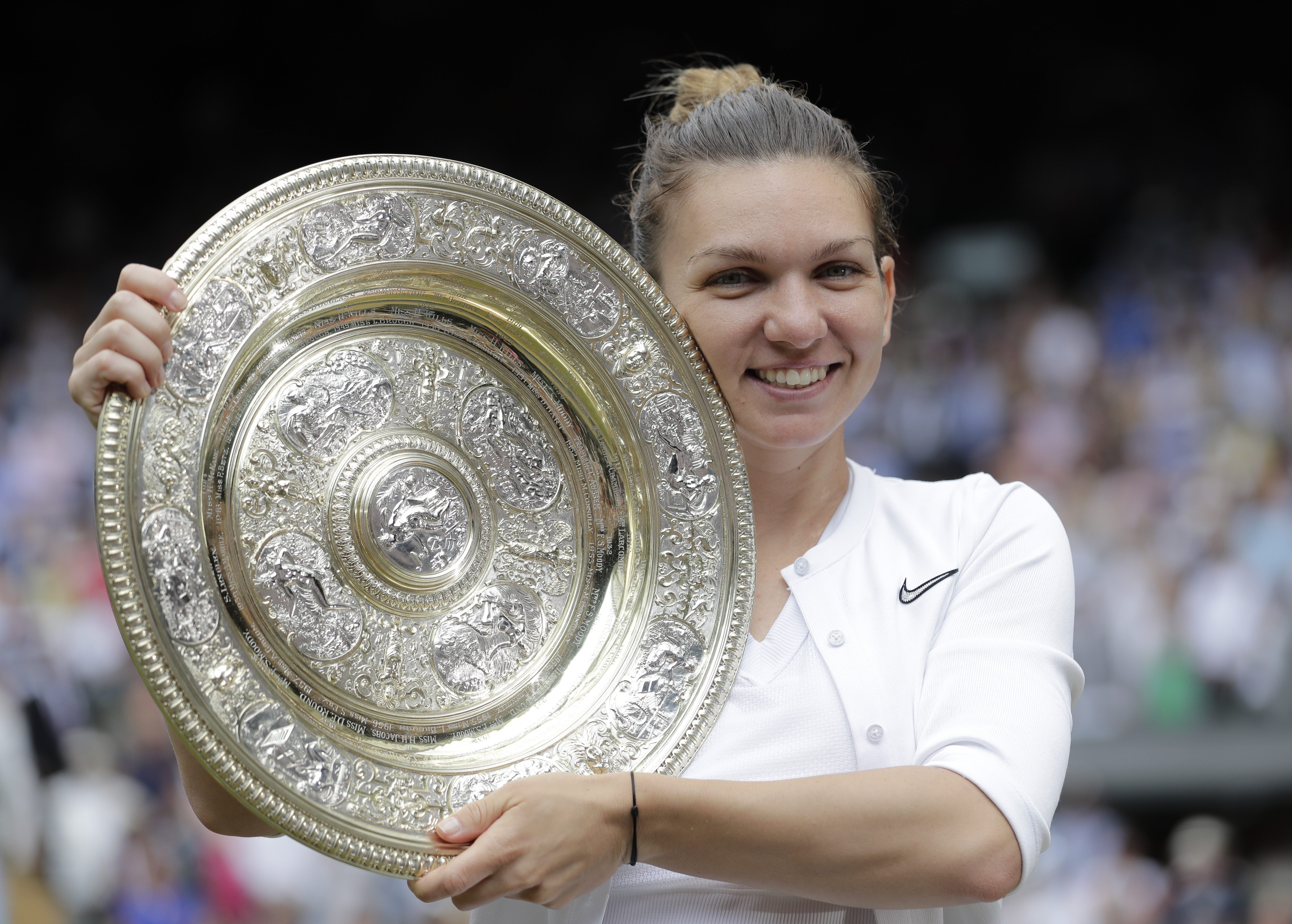 FILE - Romania's Simona Halep holds the trophy after defeating Serena Williams in the women's singles final of the Wimbledon Tennis Championships in London, July 13, 2019. Two-time Grand Slam champion Simona Halep has been suspended from professional tennis for four years for alleged doping violations, the International Tennis Integrity Agency said Tuesday, Sept. 12, 2023. 