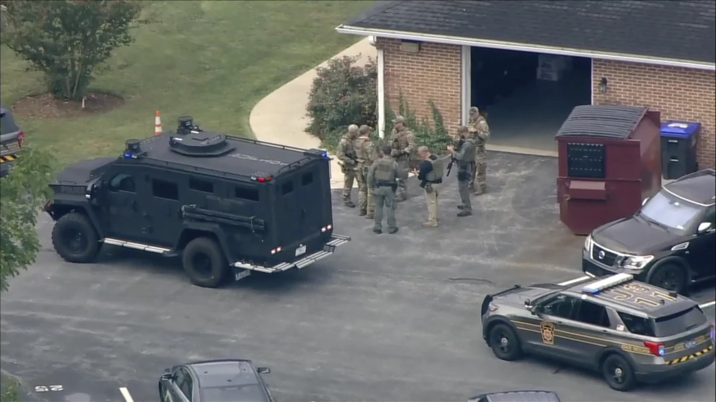 Law enforcement agents stand by an armored vehicle with Danelo Souza Cavalcante inside at the Pennsylvania State Police barracks at Avondale, Pa., on Wednesday. Cavalcante was captured Wednesday after eluding hundreds of searchers for two weeks.