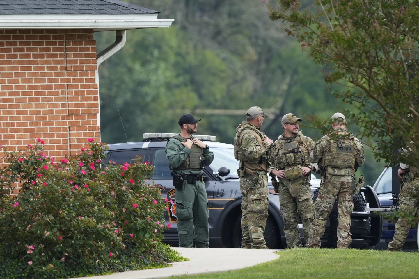 Law enforcement agents stand by as Danelo Souza Cavalcante sits inside an armored vehicle at the Pennsylvania State Police barracks at Avondale, Pa., on Wednesday. Cavalcante was captured Wednesday after eluding hundreds of searchers for two weeks.