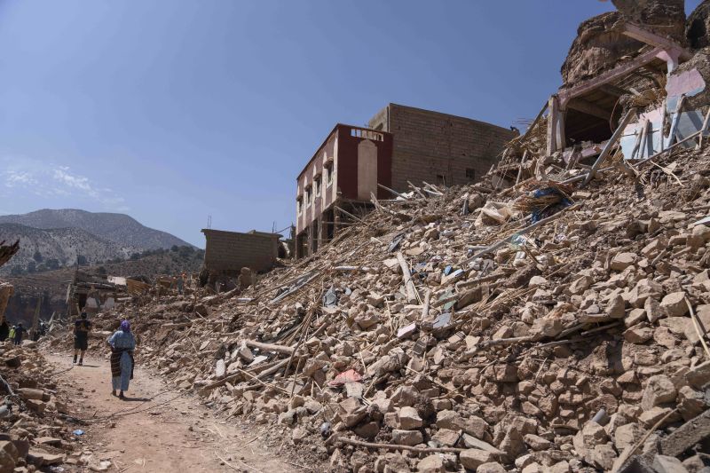 People walk amid the wreckage which was caused the earthquake, in the town of Imi N'tala, outside Marrakech, Morocco, Tuesday.
