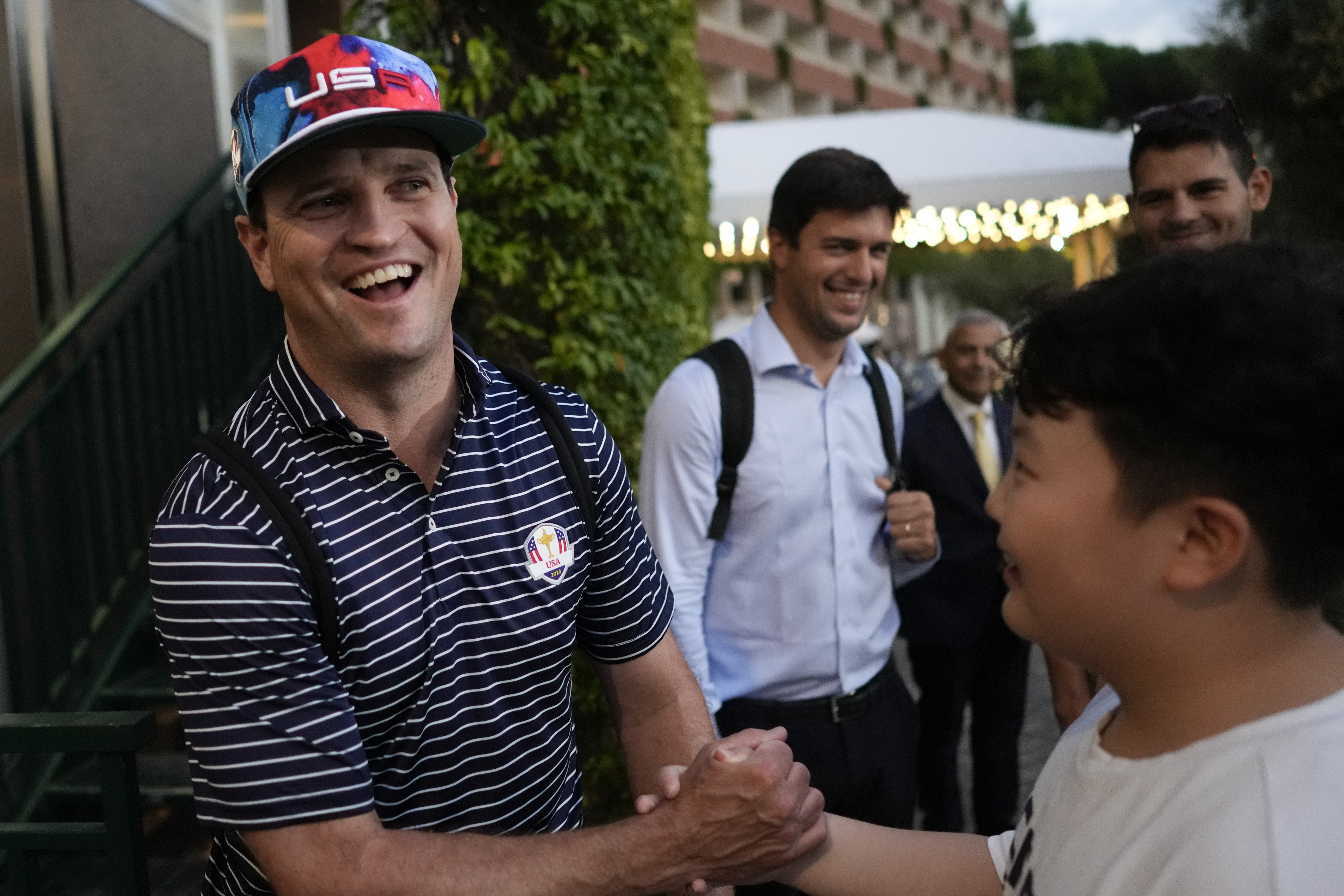 USA Ryder Cup team captain Zach Johnson shakes hands with a fan as he returns with members of his team at a hotel in Rome, Friday, Sept. 8, 2023, at the end of a practice session at the Marco Simone golf club. 