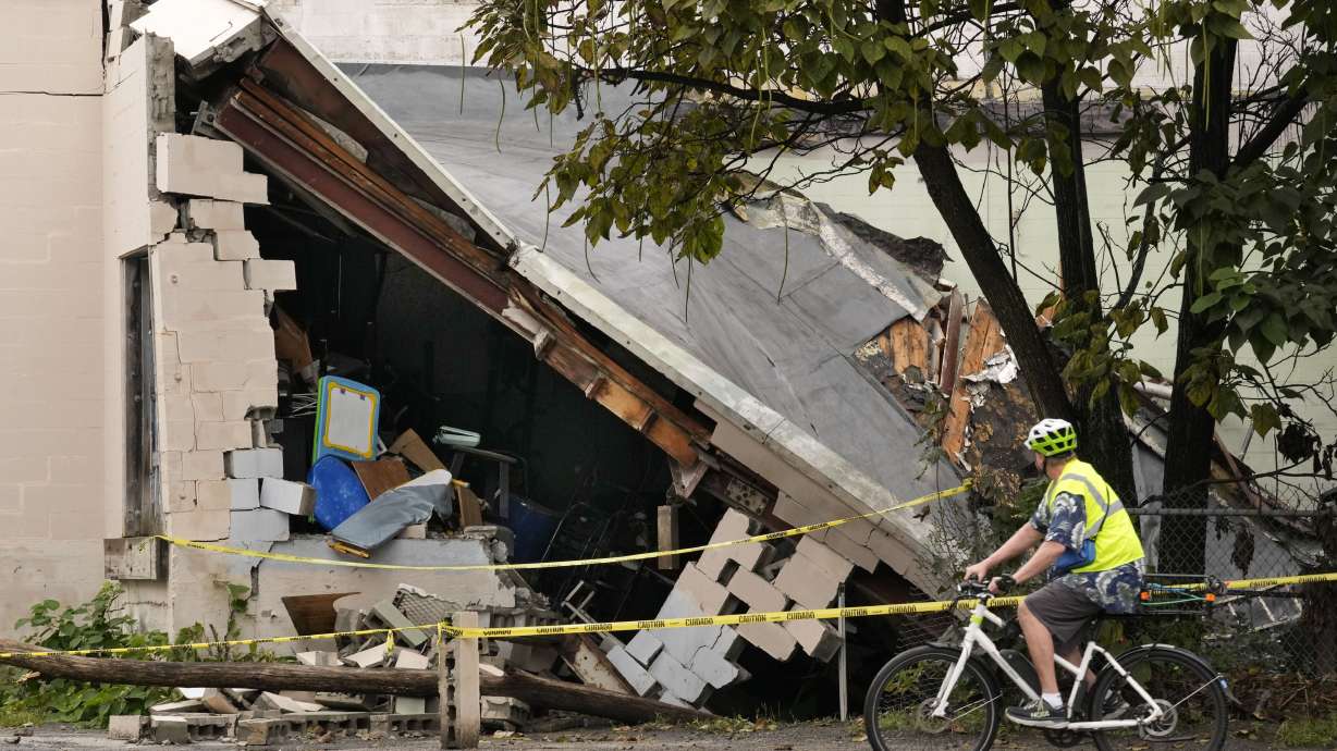 A man views damage to a building caused by recent flooding, Wednesday at the Hilton & Cook Marketplace in Leominster, Mass.