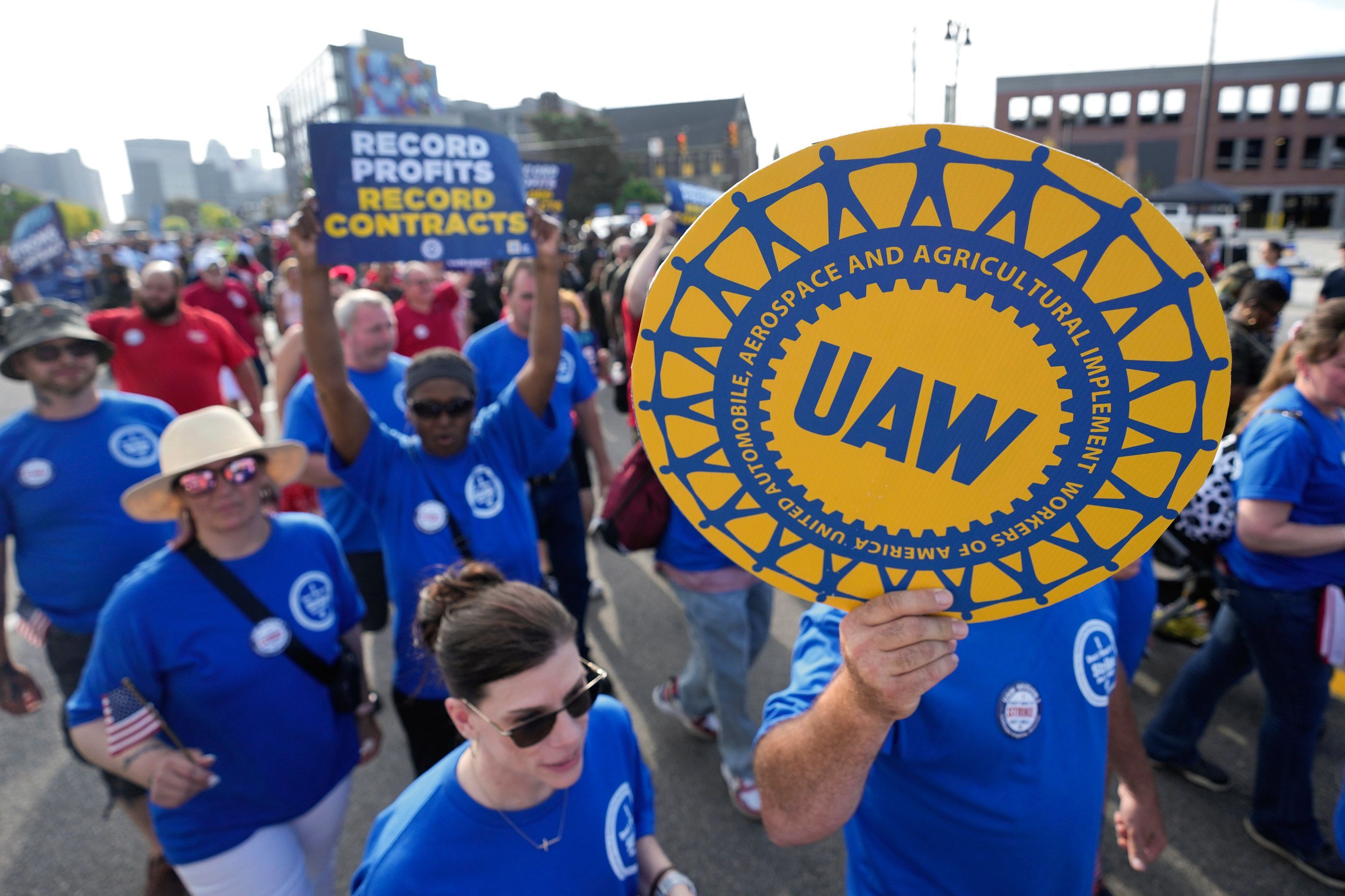 United Auto Workers members walk in the Labor Day parade in Detroit, Sept. 4. The United Auto Workers union is on strike against General Motors, Ford and Stellantis, the first time in its history that it has struck all three of the nation's unionized automakers at the same time.