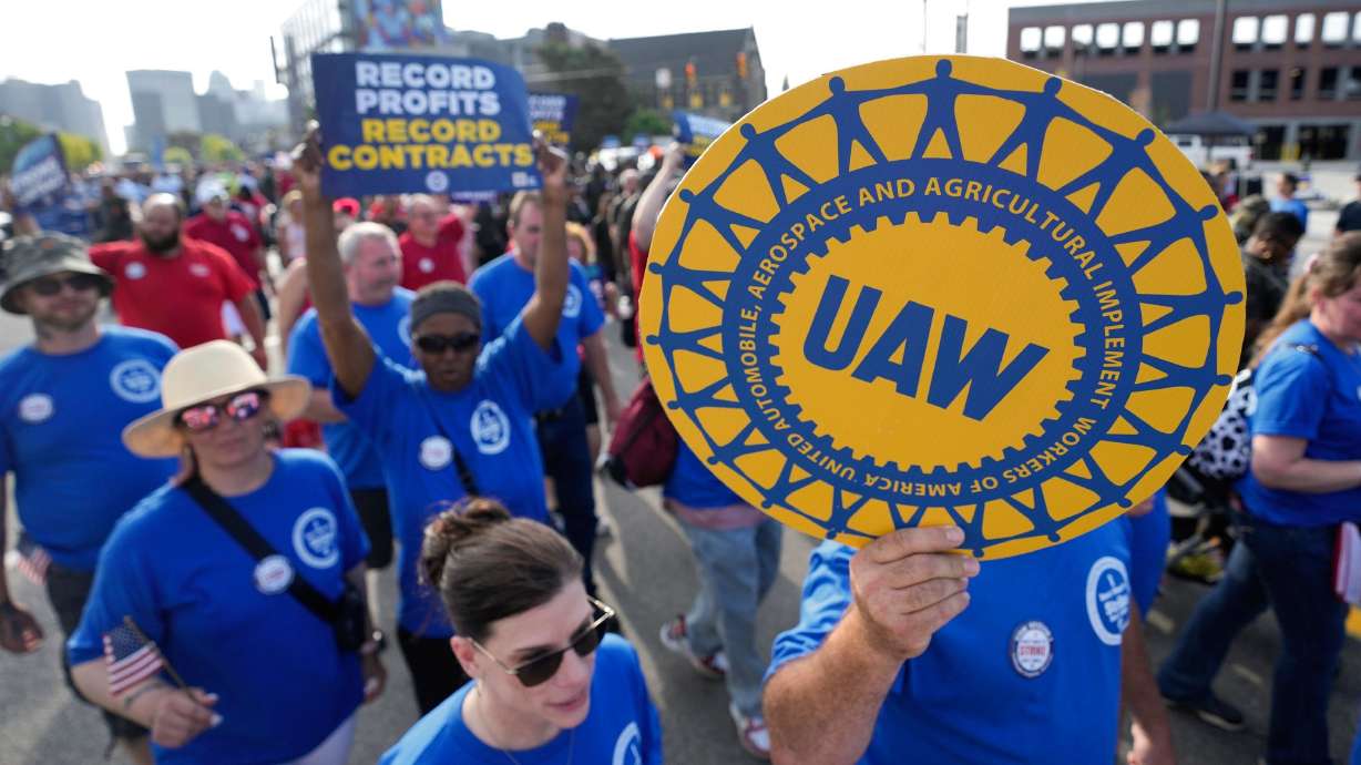 United Auto Workers members walk in the Labor Day parade in Detroit, Sept. 4. The United Auto Workers union is on strike against General Motors, Ford and Stellantis, the first time in its history that it has struck all three of the nation's unionized automakers at the same time.