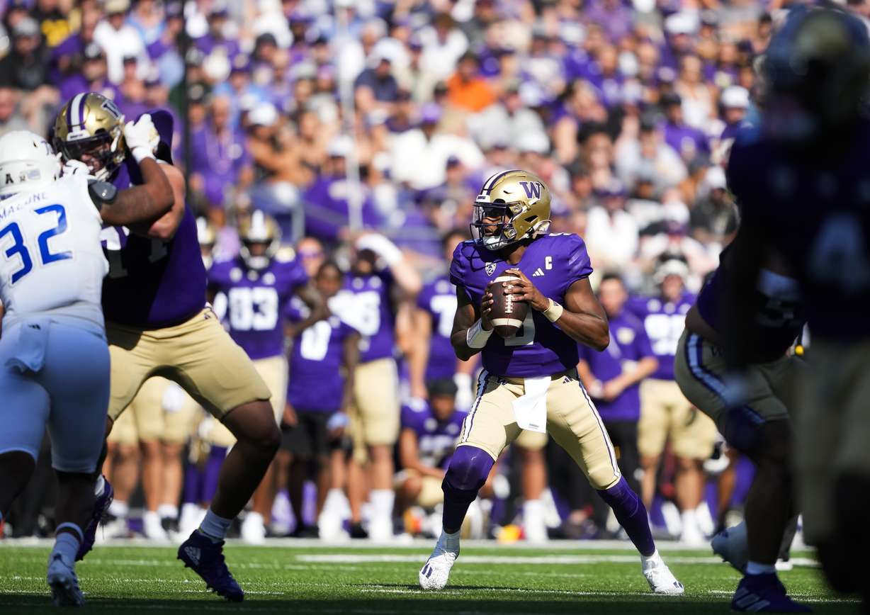 Washington quarterback Michael Penix Jr., center right, drops back to throw against Tulsa during the first half of an NCAA college football game Saturday, Sept. 9, 2023, in Seattle.