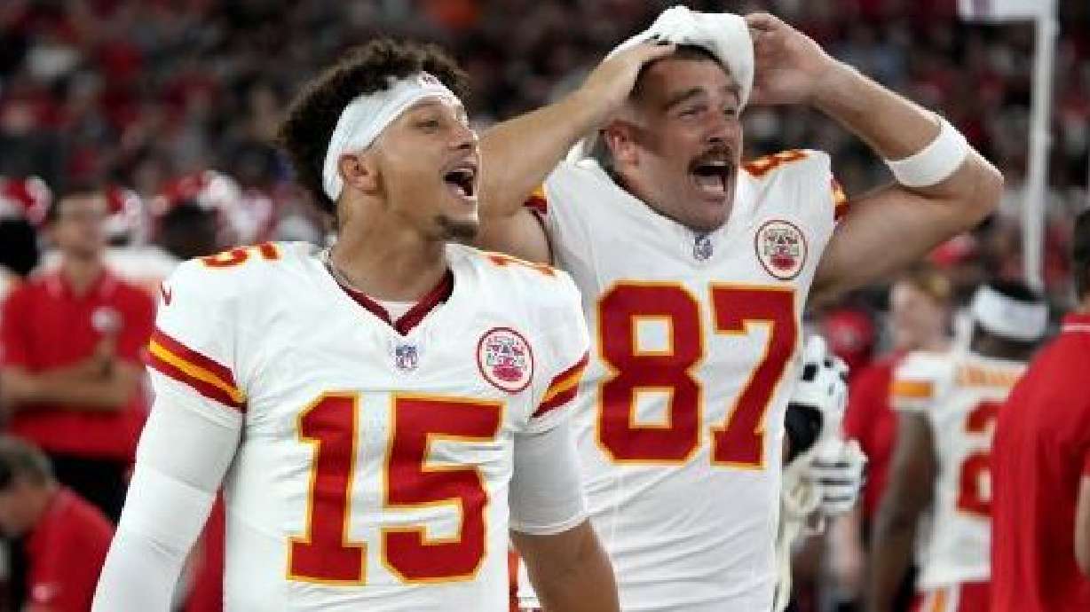 Kansas City Chiefs quarterback Patrick Mahomes (15) and tight end Travis Kelce (87) cheer from the sidelines during the first half of an NFL preseason football game against the Arizona Cardinals, Saturday, Aug. 19, 2023, in Glendale, Ariz.