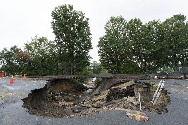 Train tracks on the Fitchburg Line extend over an area washed out by recent flooding, Wednesday, in Leominster, Mass. The damage forced the closure of a commuter train line.