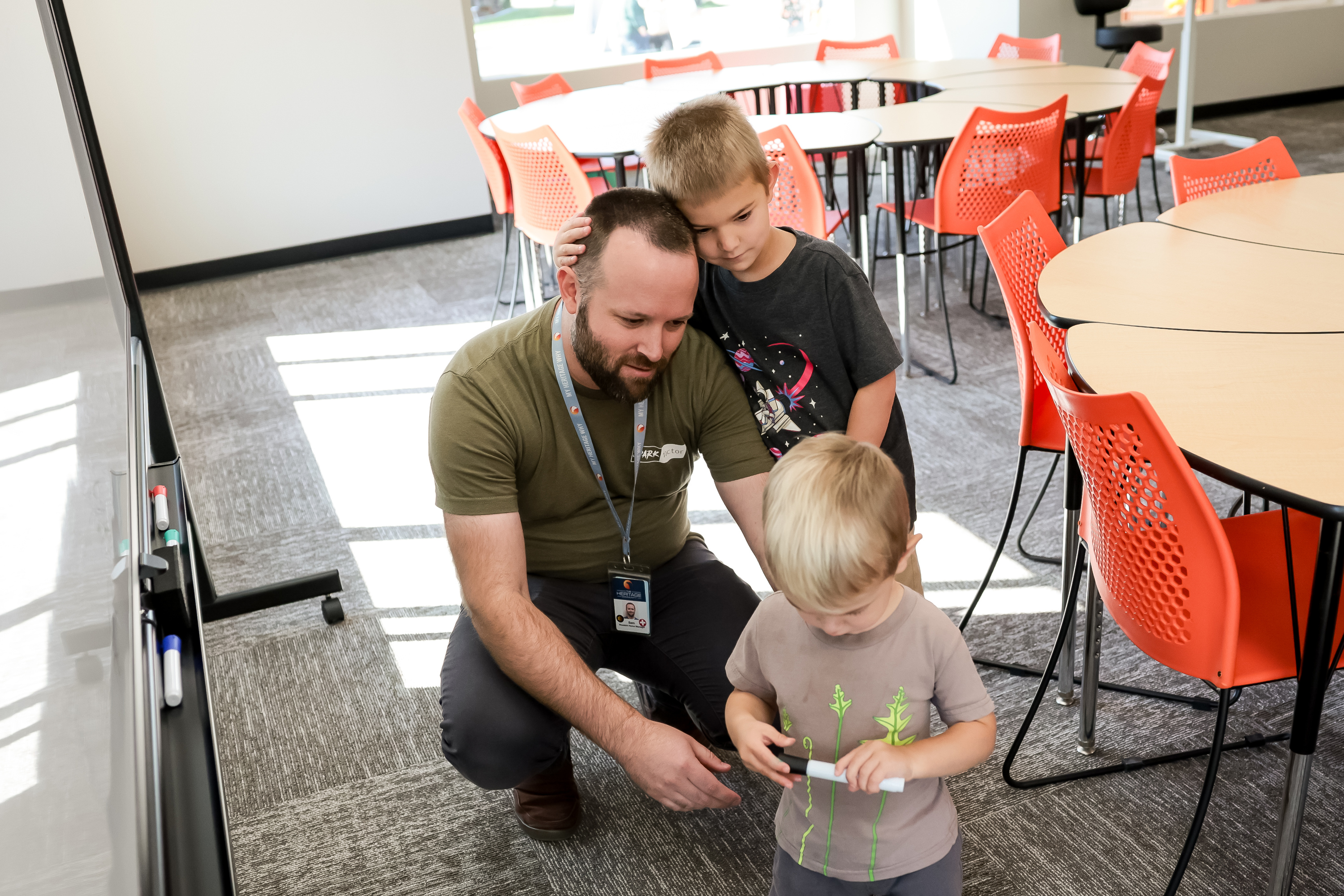 Sam Crossley, a program manager at the Heritage Community, and his sons, Sawyer, 4, and Cayden, 1, tour the new Spark Academy building in Provo on Thursday.