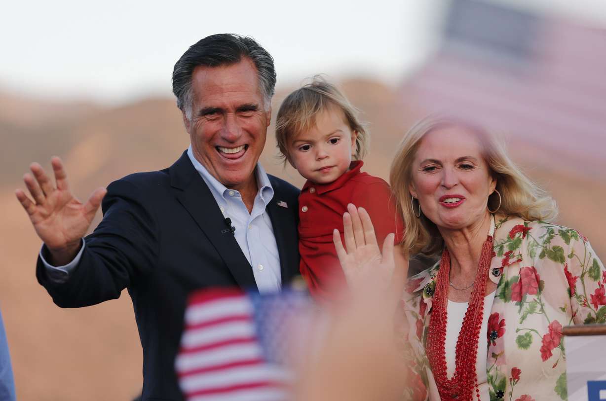 Former GOP presidential nominee Mitt Romney holds his grandson Dane Romney, 2, while he and his wife, Ann, wave after addressing supporters at their campaign headquarters during an election night party, June 26, 2018, in Orem, Utah.