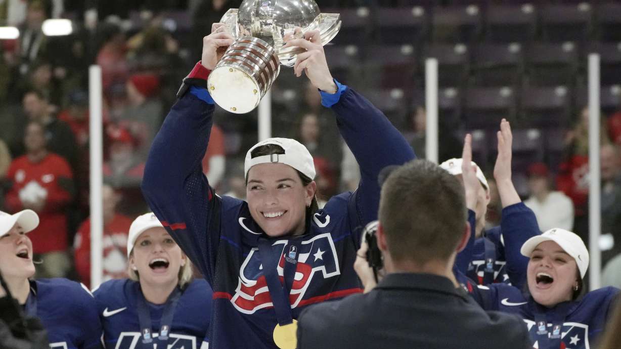 United States forward Hilary Knight, center, holds the cup as she celebrates with teammates after defeating Canada in the gold medal game at the women's world hockey championships in Brampton, Ontario, April 16, 2023.
