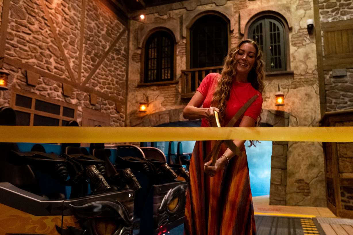 Julie Freed, director of special events at Lagoon, cuts the ribbon for the park's newest ride, Primordial, on its opening day at the amusement park in Farmington on Friday.