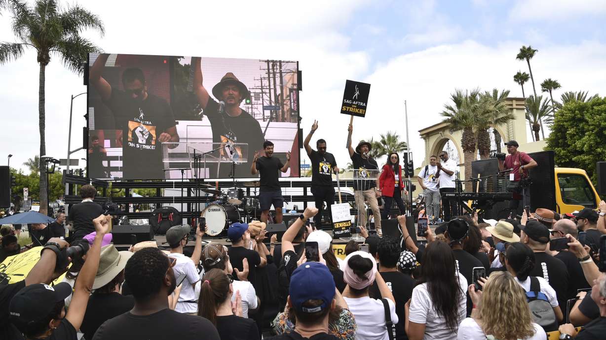 Kal Penn and John Cho speak outside Paramount Pictures Studio on Sept. 13, in Los Angeles. The film and TV industries remain paralyzed by actor and screenwriter strikes.