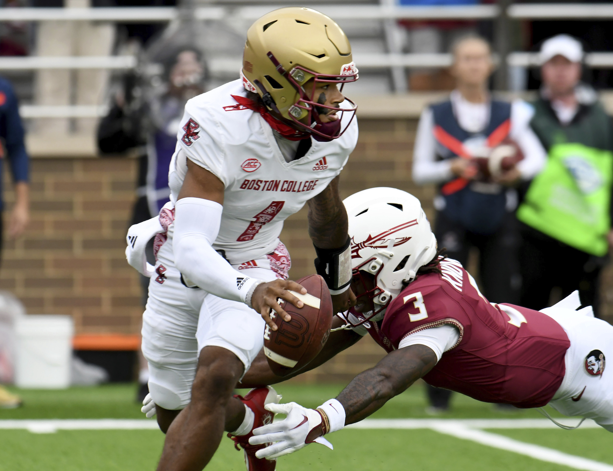 Boston College quarterback Thomas Castellanos (1) escapes the grasp of Florida State defensive back Kevin Knowles II (3) during the first half of an NCAA college football game, Saturday, Sept. 16, 2023 in Boston. 