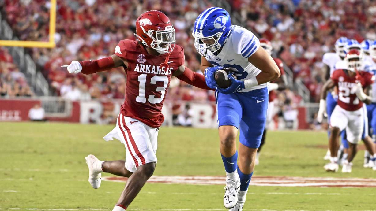 BYU tight end Isaac Rex (83) catches a pass in front of Arkansas defensive back Alfahiym Walcott (13) during the first half of an NCAA college football game, Saturday, Sept. 16, 2023, in Fayetteville, Ark.