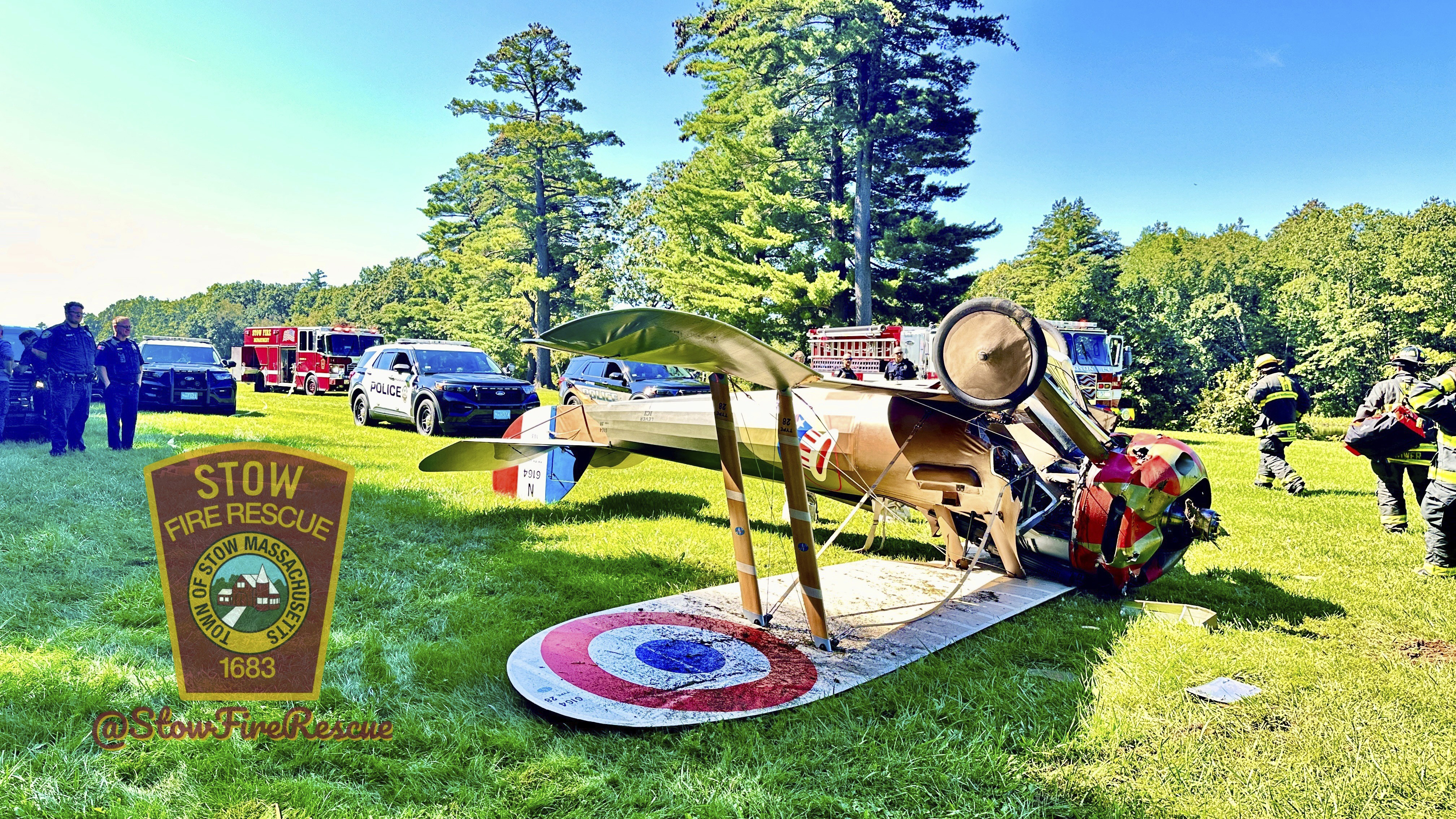 Responders work the scene where a World War I-era plane crashed and flipped onto its roof near the American Heritage Museum, in Stow, Mass., Sunday. The pilot was not hurt.
