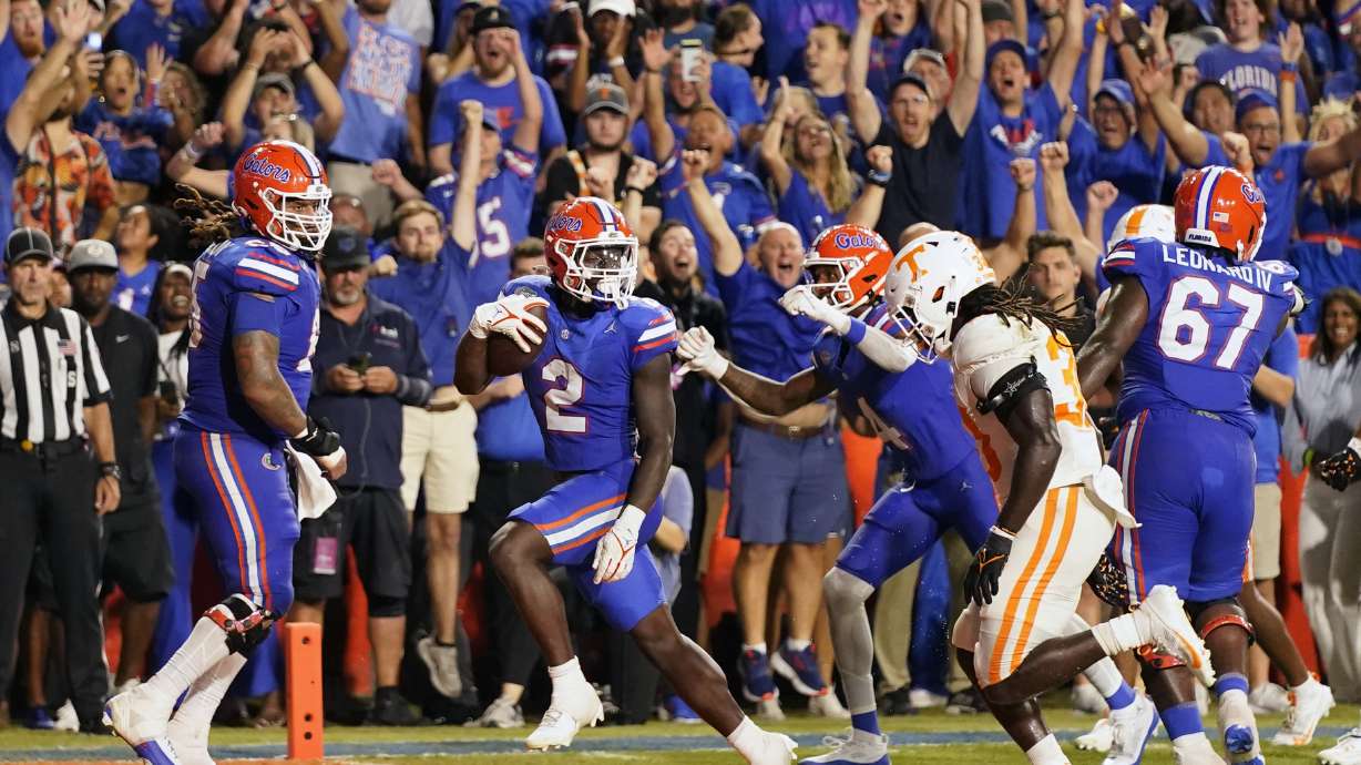 Florida running back Montrell Johnson Jr. (2) scores a touchdown past Tennessee defensive lineman Roman Harrison, front right, on an 18-yard pass play during the first half of an NCAA college football game, Saturday, Sept. 16, 2023, in Gainesville, Fla.