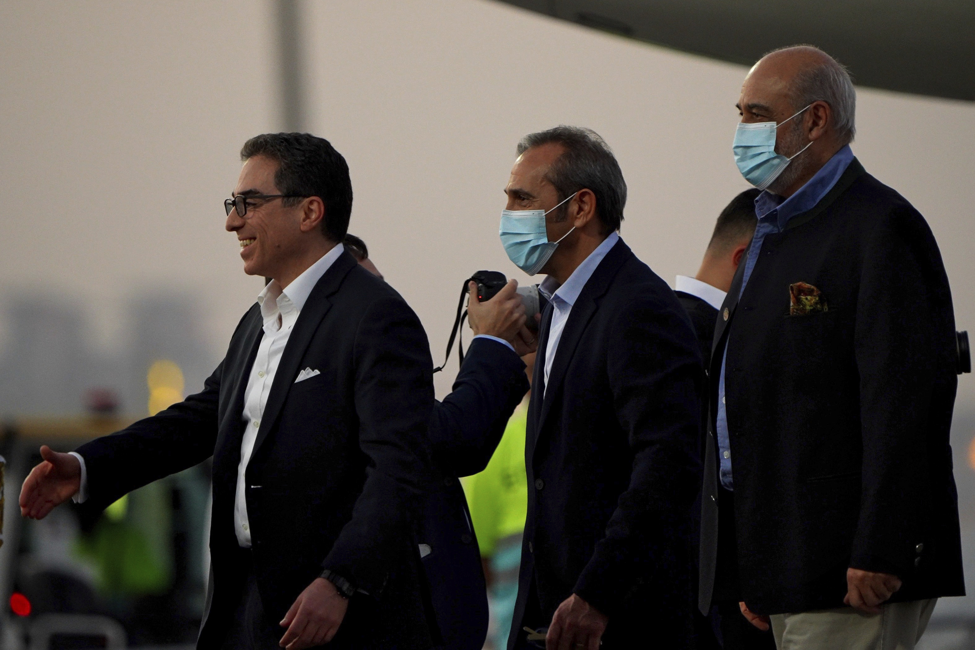 From left, Siamak Namazi, Emad Sharghi and Morad Tahbaz walk away from a Qatar Airways flight that brought them out of Tehran and to Doha, Qatar, Monday. Five prisoners sought by the U.S. in a swap with Iran were freed Monday and headed home as part of a deal that saw nearly $6 billion in Iranian assets unfrozen.