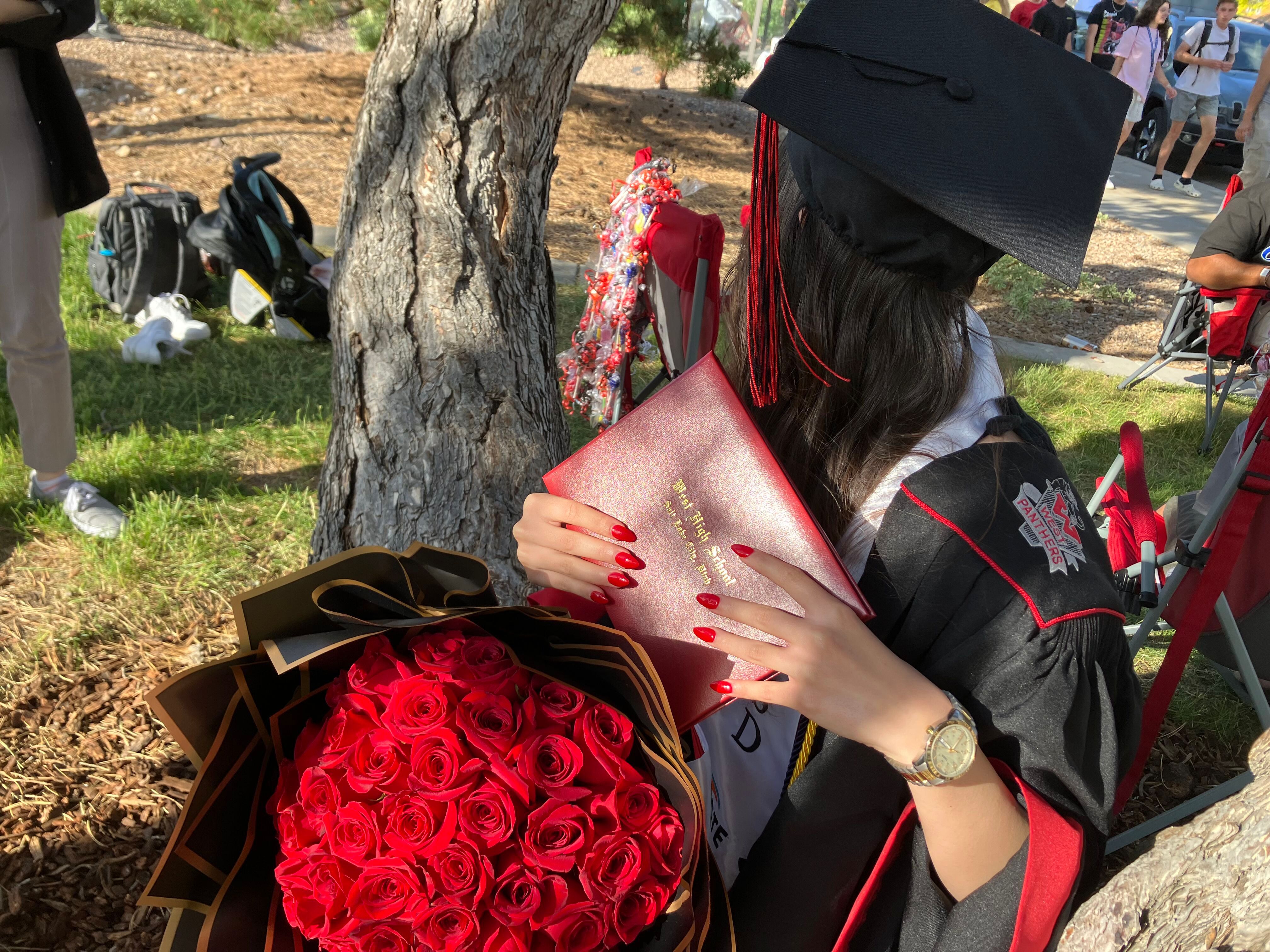 A 17-year-old graduate from West High School poses for a picture after a ceremony at the University of Utah in Salt Lake City on June 9, the day after President Joe Biden announced humanitarian parole would be extended for Afghan arrivals like her. Her face is not shown to protect her family in Afghanistan.