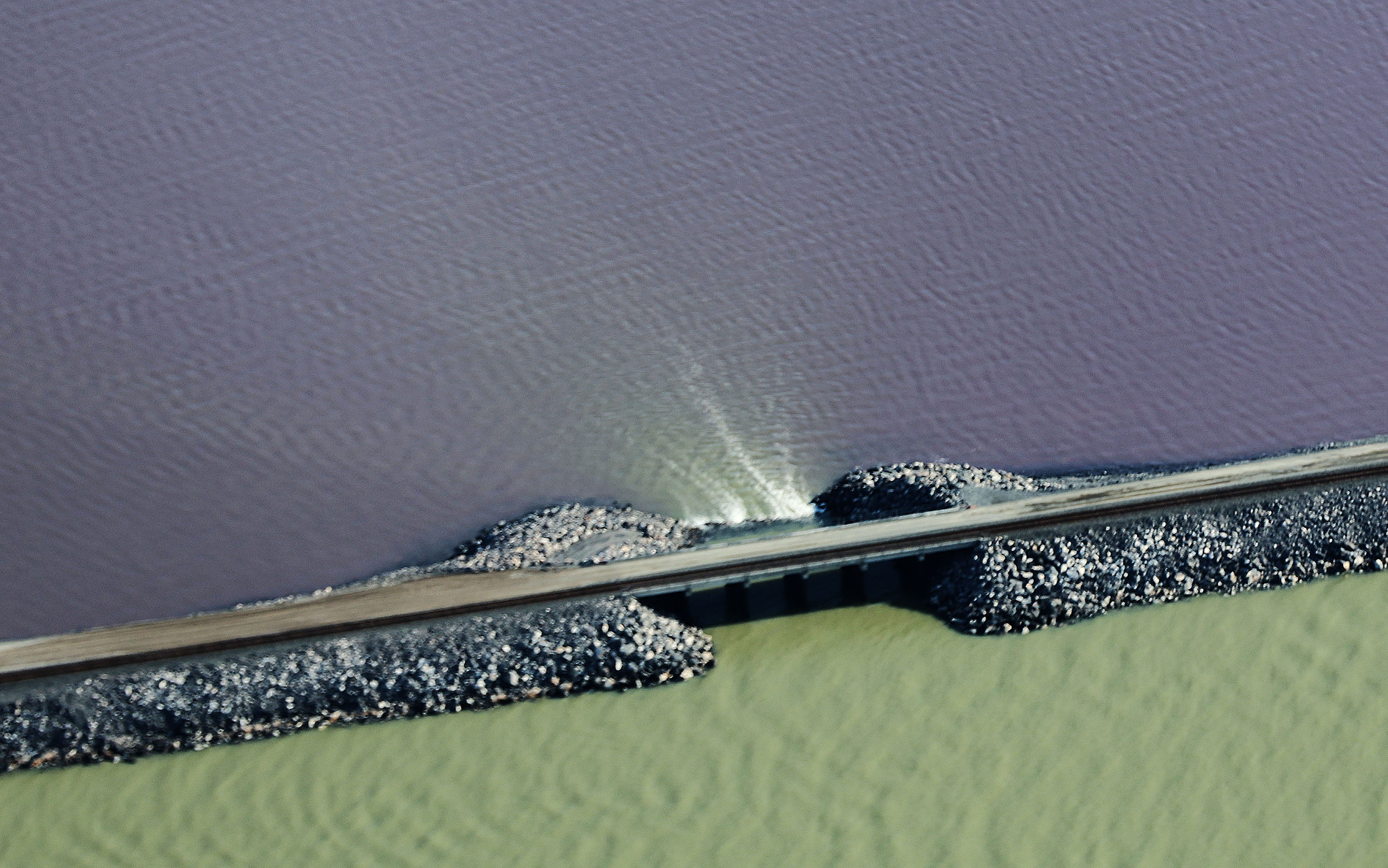 Water flows through a breach in the Great Salt Lake railroad causeway on May 3. The lake's northern arm remains within 1 foot of its record low set last year.
