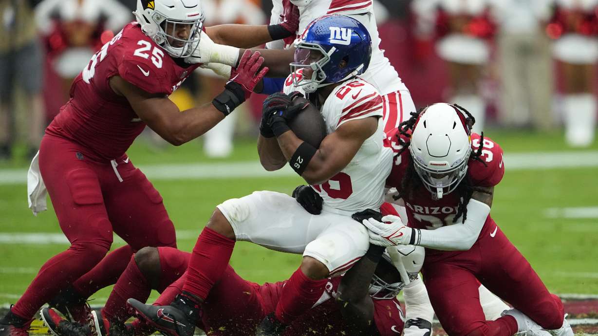 Arizona Cardinals safety Andre Chachere, right tackles New York Giants running back Saquon Barkley (26) during the first half of an NFL football game, Sunday, Sept. 17, 2023, in Glendale, Ariz.