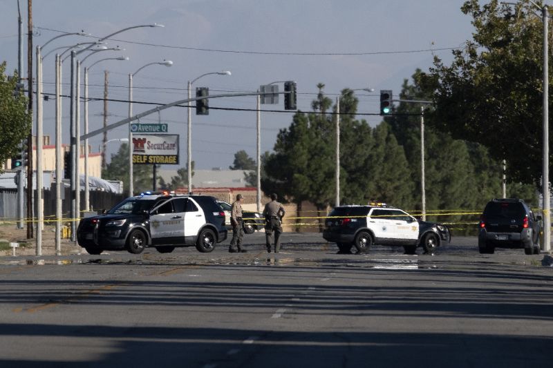 Police cars block off a street where a sheriff's deputy was shot while in his patrol car in Palmdale, Calif. on Sunday.