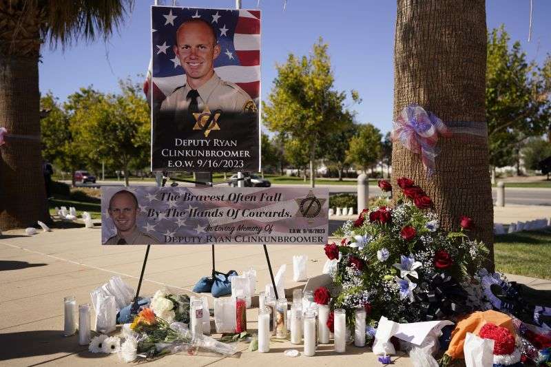 A shrine to honor deputy Ryan Clinkunbroomer is placed outside of the Palmdale Sheriff's Station during a press to announce an arrest in the ambush killing of the Los Angeles County sheriff's deputy Monday, in Palmdale, Calif. Clinkunbroomer was shot and killed while sitting in his patrol car Saturday evening in Palmdale.